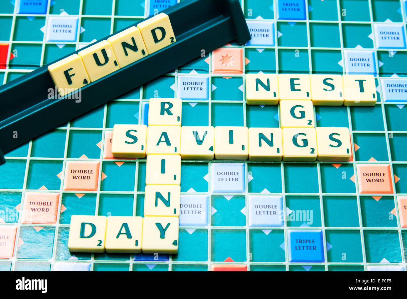 savings rainy day nest egg fund pension saving words using scrabble tiles to illustrate spelling