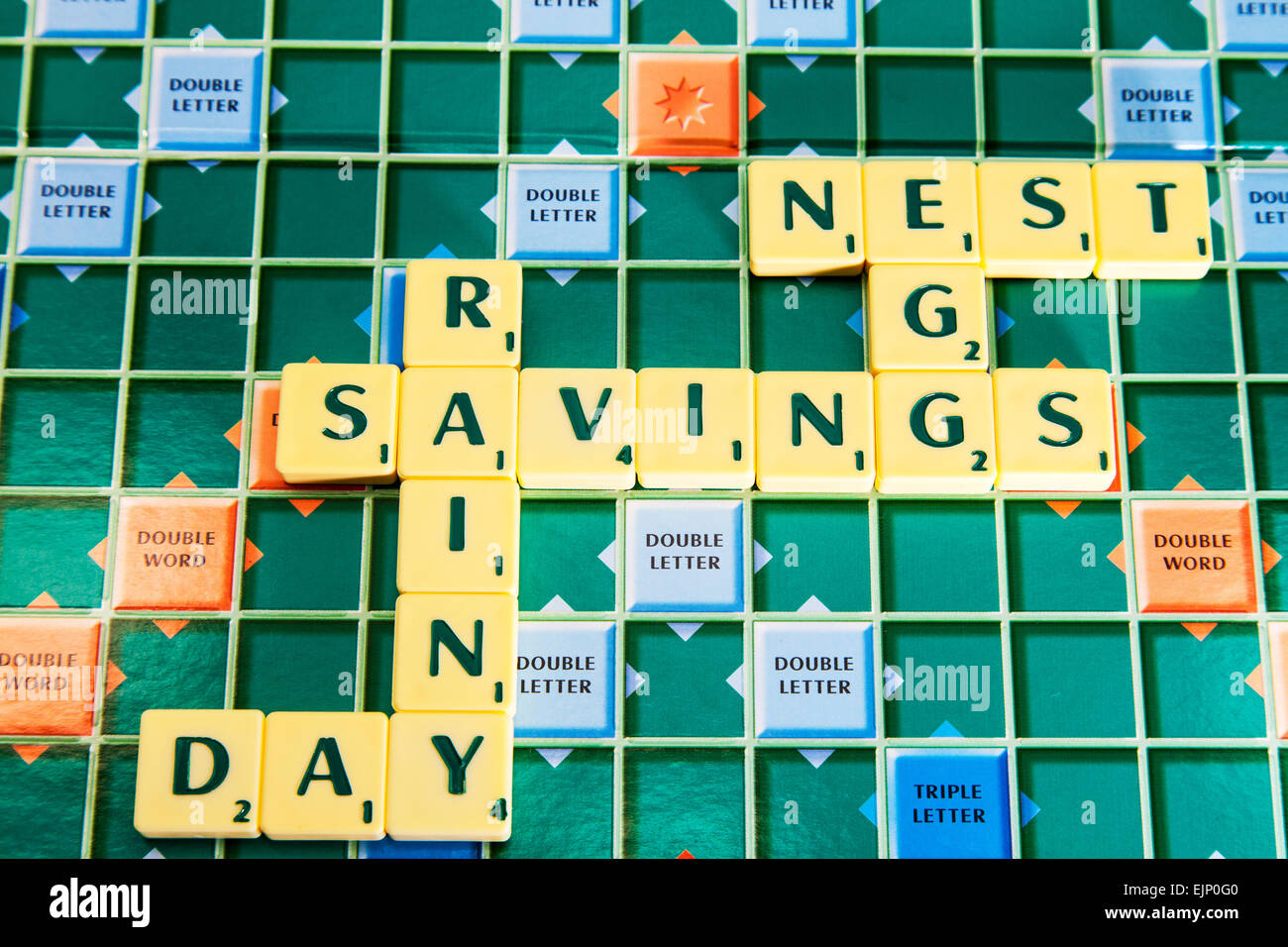 rainy day savings nest egg pension save hide words using scrabble tiles to illustrate spelling spell out Stock Photo