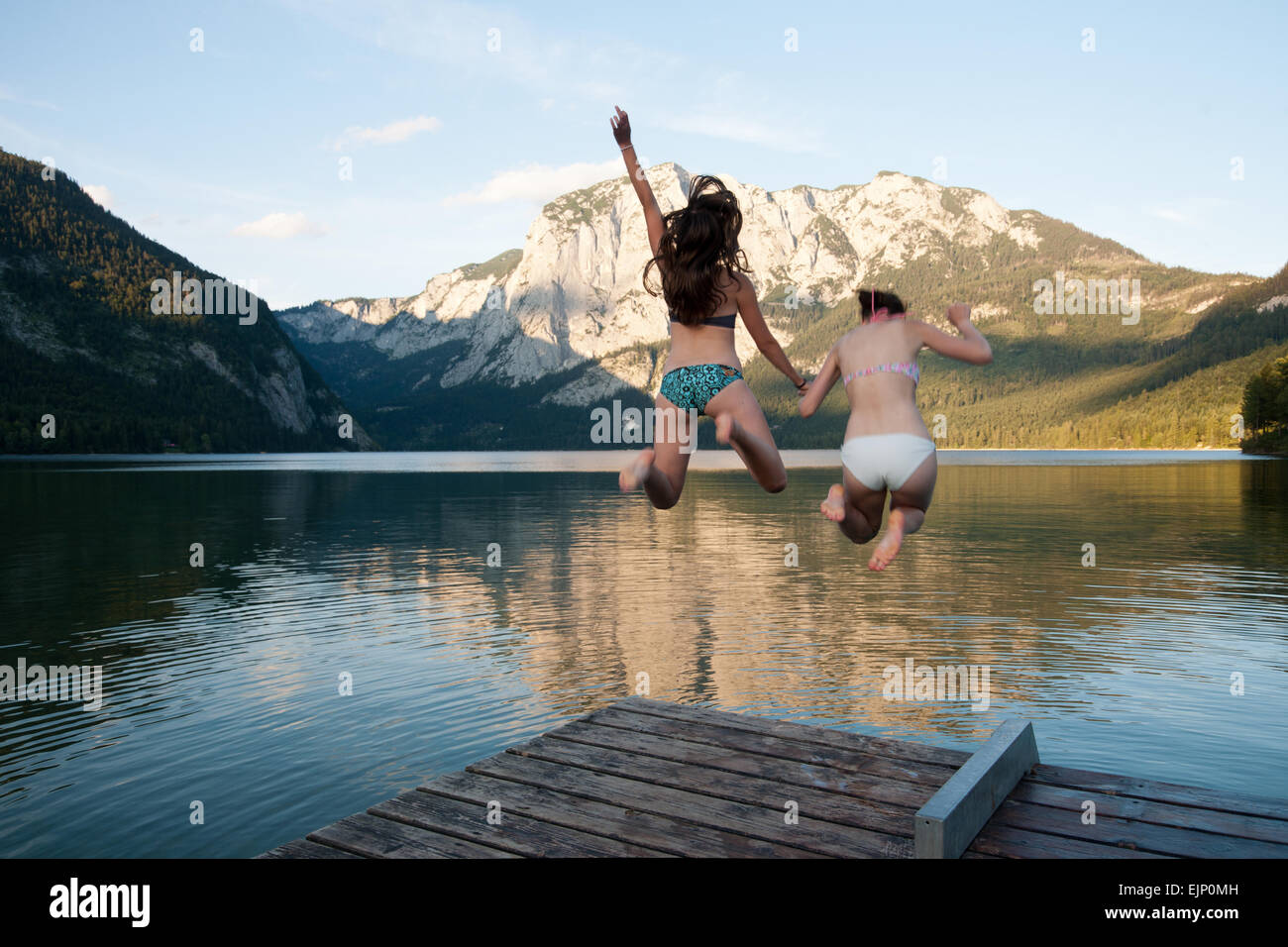 2 girls jumping into the lake, Altaussee, Salzkammergut, Styria, Austria Stock Photo