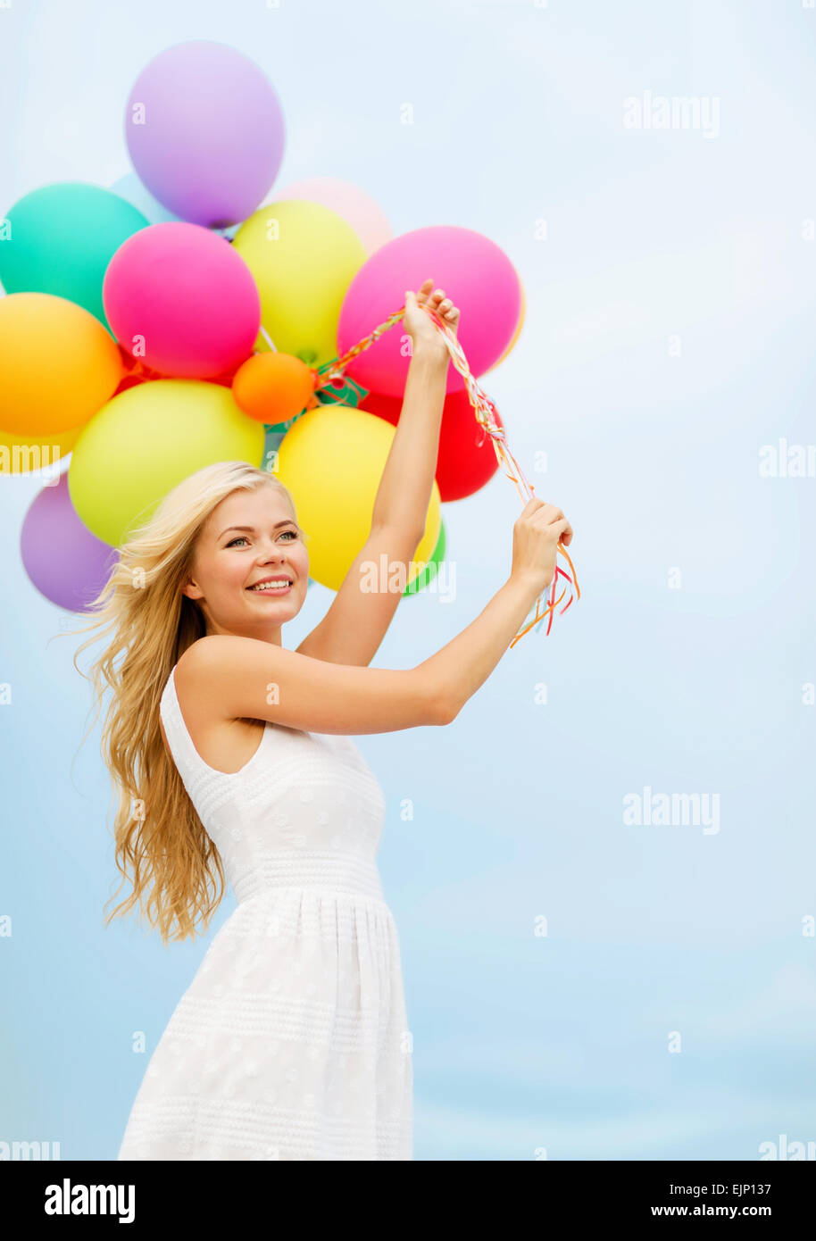 smiling woman with colorful balloons outside Stock Photo