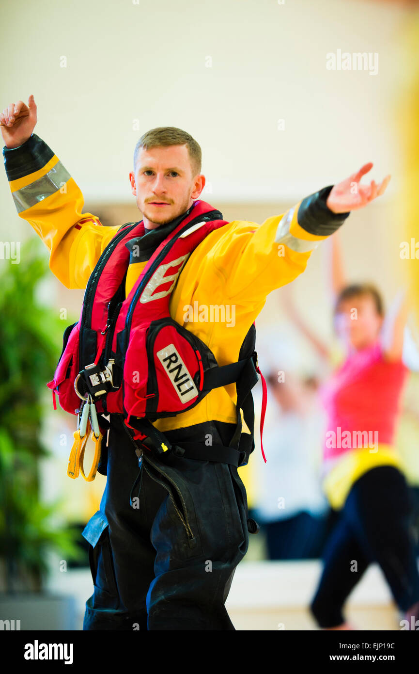 Crew members in full immersion survival kit taking part in a 'Zumbathon' fund raising event at Aberystwyth University sports  centre in aid of the Royal National Lifeboat institution (RNLI) Stock Photo