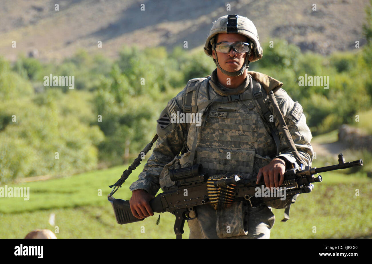 U.S. Army Spc. Brandon Rodriguez, a combat infantryman from 1st Platoon, Delta Company, 1st Battalion, 4th Infantry Regiment, U.S. Army Europe, carries an M-240B Machine Gun as he maneuvers through rough terrain during a patrol outside Forward Operating Base Baylough in Zabul province, Afghanistan, on June 12, 2010.   Spc. Eric Cabral, U.S. Army.  Released Stock Photo