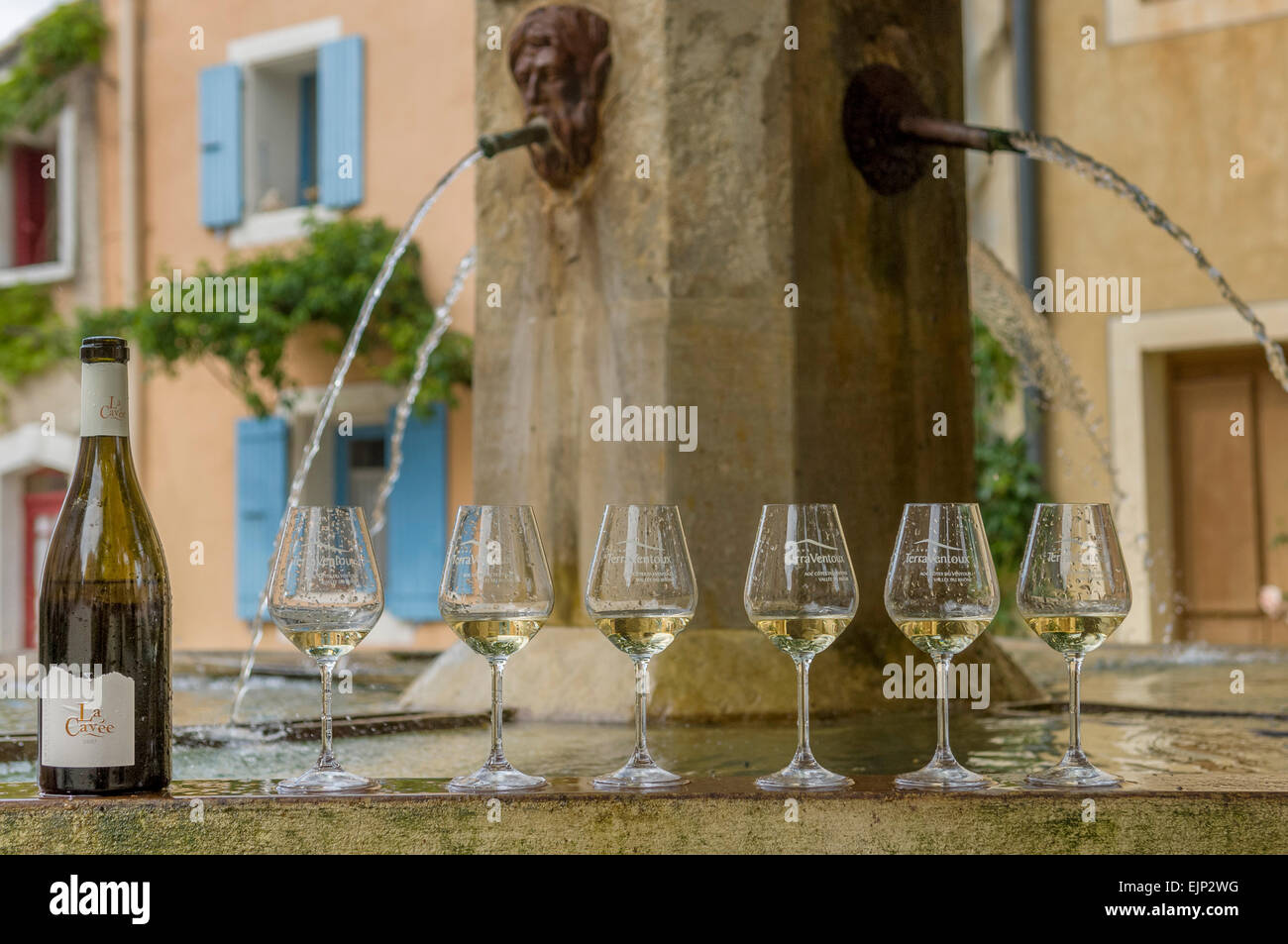 Wine bottle and glasses beside a water fountain at Flassan village