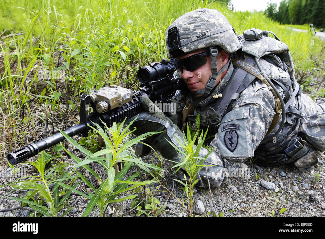 Army Pfc. Travis Watson, A Troop, 1st Squadron Airborne, 40th Cavalry Regiment, pulls perimeter security as the unit conducts a section level dismounted live fire at the Infantry Platoon Battle Course, June 19, 2013 at Joint Base Elmendorf-Richardson, Alaska. Soldiers traversed the 250-meter course in teams, reacting to enemy contact, conducting hasty attacks using bounding overwatch techniques to reach their objectives, and using proper procedures for reporting casualties and resupply needs. Stock Photo