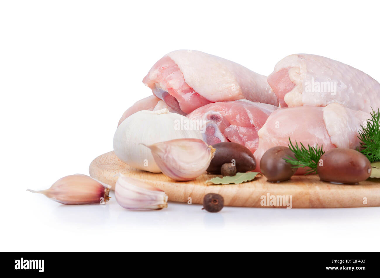 Raw chicken legs with olives and garlic on a wooden board Stock Photo