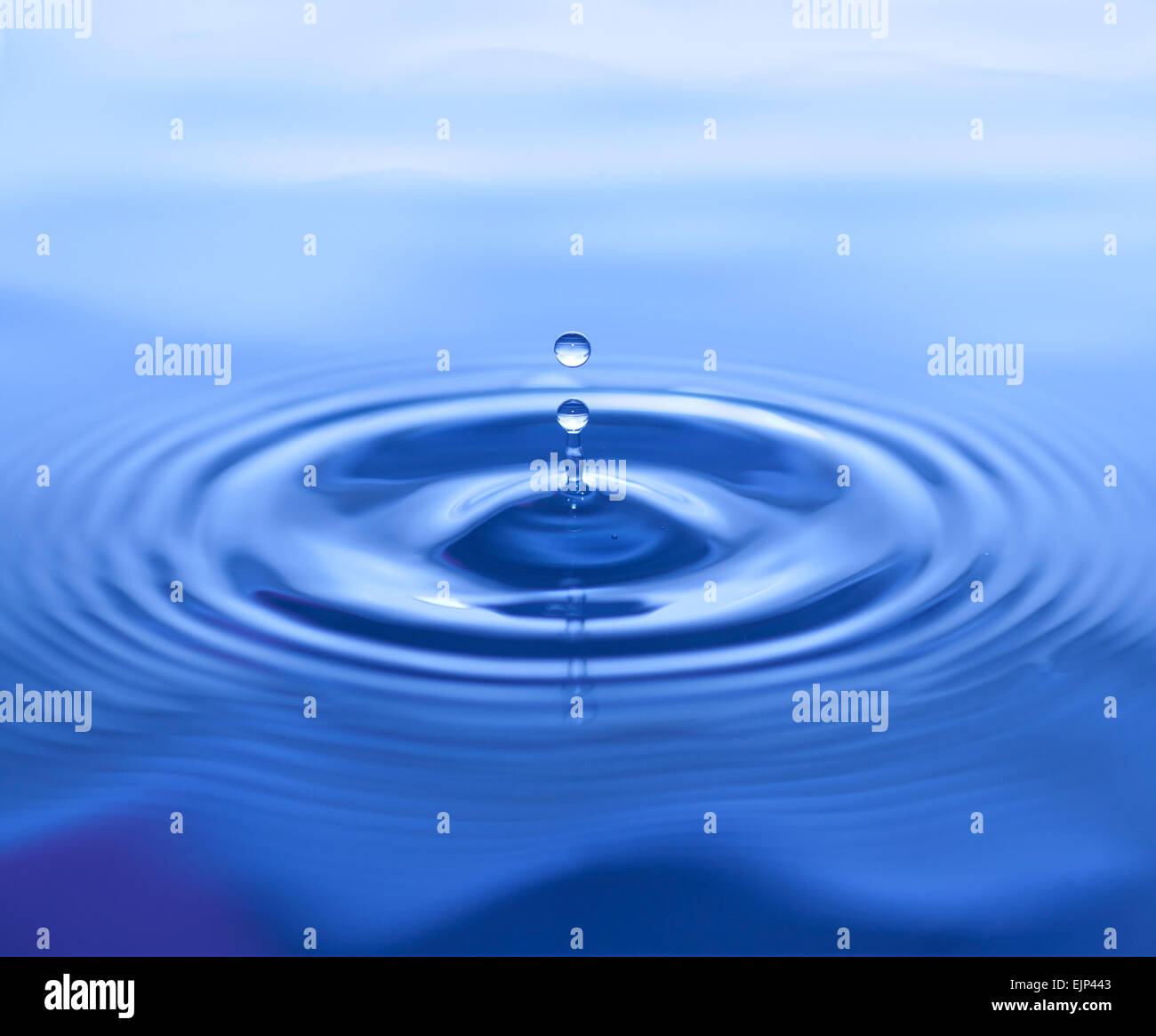 Water Drop Splash on Blue Background with Ripples Stock Photo - Alamy