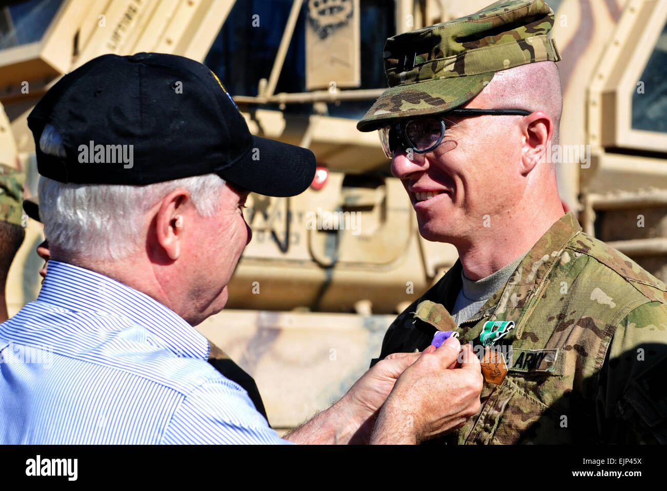 Defense Secretary Robert M. Gates presents the Purple Heart and the Army Commendation Medal with Valor to Army Capt. Jeffrey Mackinnon, 1st Battalion, 320th Field Artillery Regiment, 2nd Brigade Combat Team, 101st Airborne Division Air Assault at Combat Outpost Kowall in Afghanistan, March 8, 2011.  Defense Department photo by Cherie Cullen Stock Photo