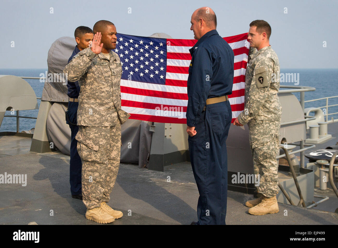 U.S. Army Staff Sgt. Robert Green of C Company, 449th Aviation Support Battalion, re-enlists during a ceremony aboard the USS Ponce AFSB I-15 in the Persian Gulf. U.S. Navy Capt. Jon P. Rodgers, the commanding officer of the ship who is from Humboldt, Tenn., had the honor of reading the re-enlistment oath. Staff Sgt. Green, of Austin, Texas, is currently deployed to the Middle East with the 36th Combat Aviation Brigade in support of Operation Enduring Freedom. Sgt. Mark Scovell Stock Photo