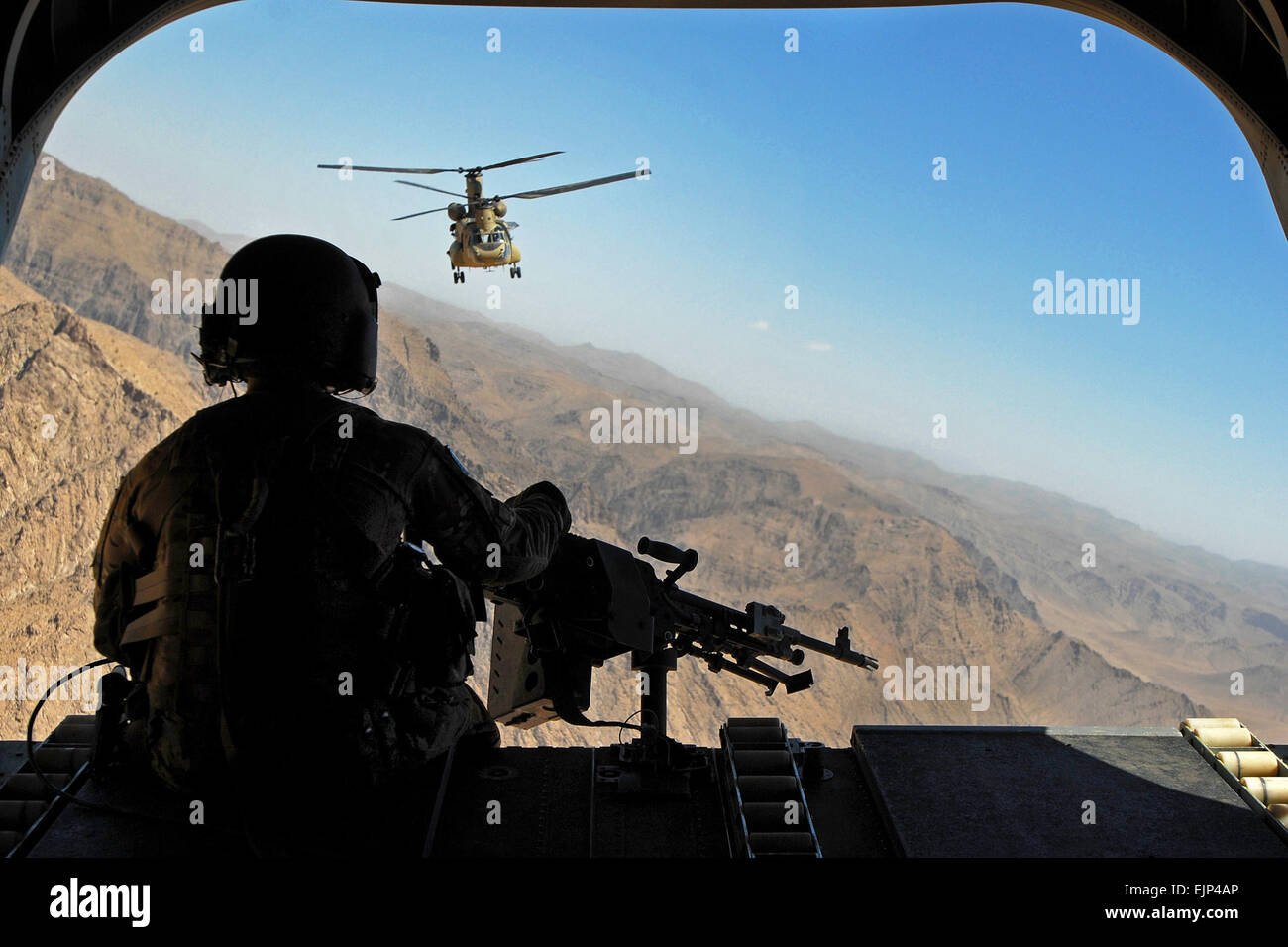 Sgt. Zach Smola, rear door gunner on a CH-47, keeps watch on the mountains in Uruzgan province, Afghanistan, May 12, 2013. The Chinooks, operated by members of Bravo Company, 2nd Battalion, 104th Aviation Regiment from the Connecticut and Pennsylvania Army National Guard, have played a vital part in the mission in Afghanistan since their arrival in December 2012 by performing resupply, retrograde, and planned missions.  Sgt. Jessi Ann McCormick Stock Photo
