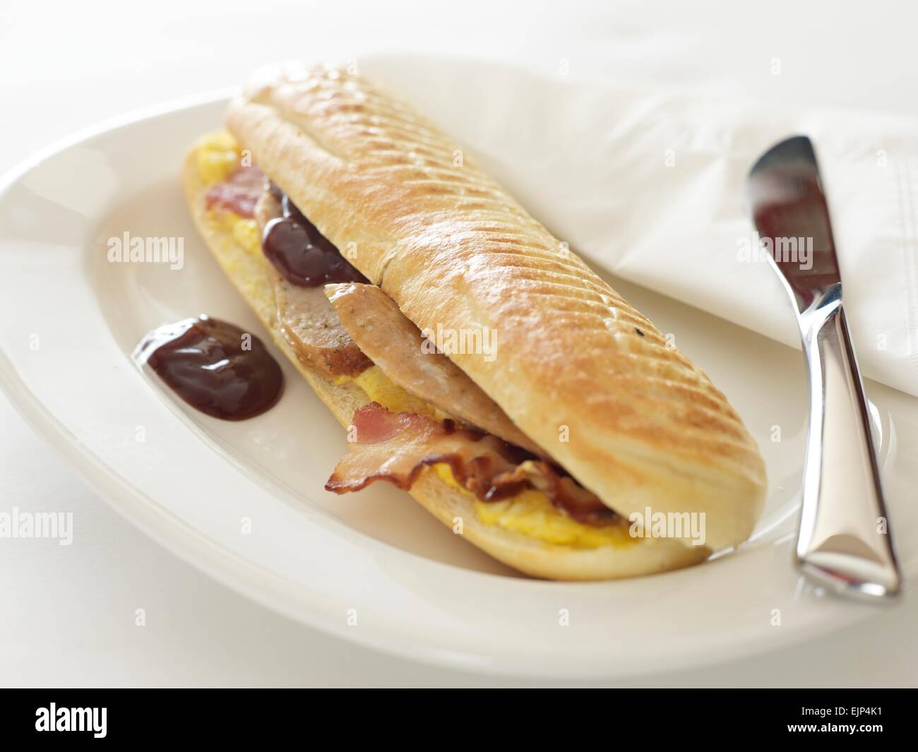 sausage egg and bacon breakfast baguette with brown sauce Stock Photo
