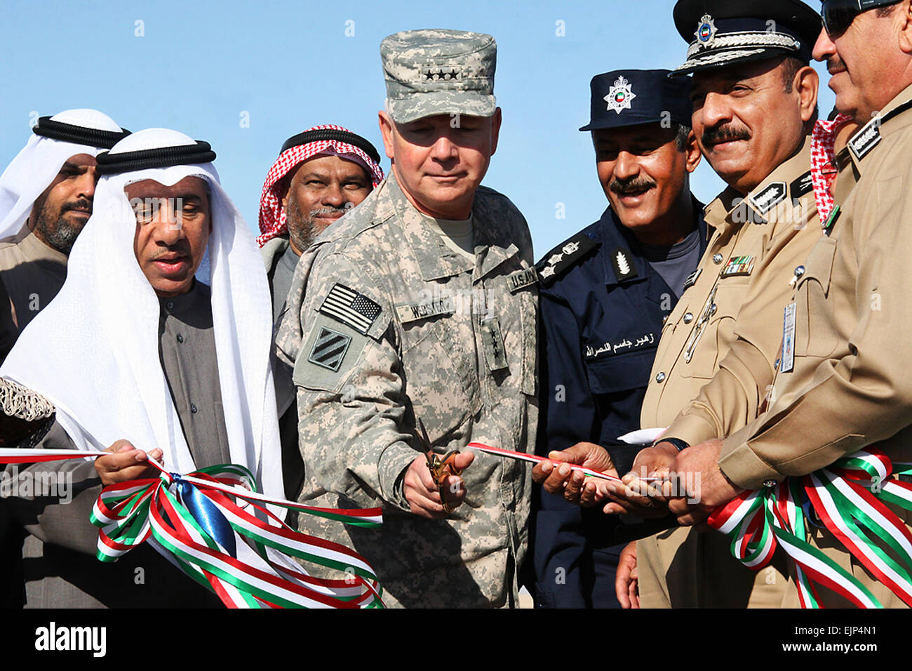 U.S. Army Lt. Gen. William G. Webster, the commanding general of Third Army, cuts a ribbon with Kuwait’s military and highway patrol personnel, Dec. 30, 2009, to celebrate the opening of a new military convoy route. The Kuwaiti government provided the route for U.S. troops traveling between camps across Kuwait.  Spc. Jason C. Adolphson Stock Photo
