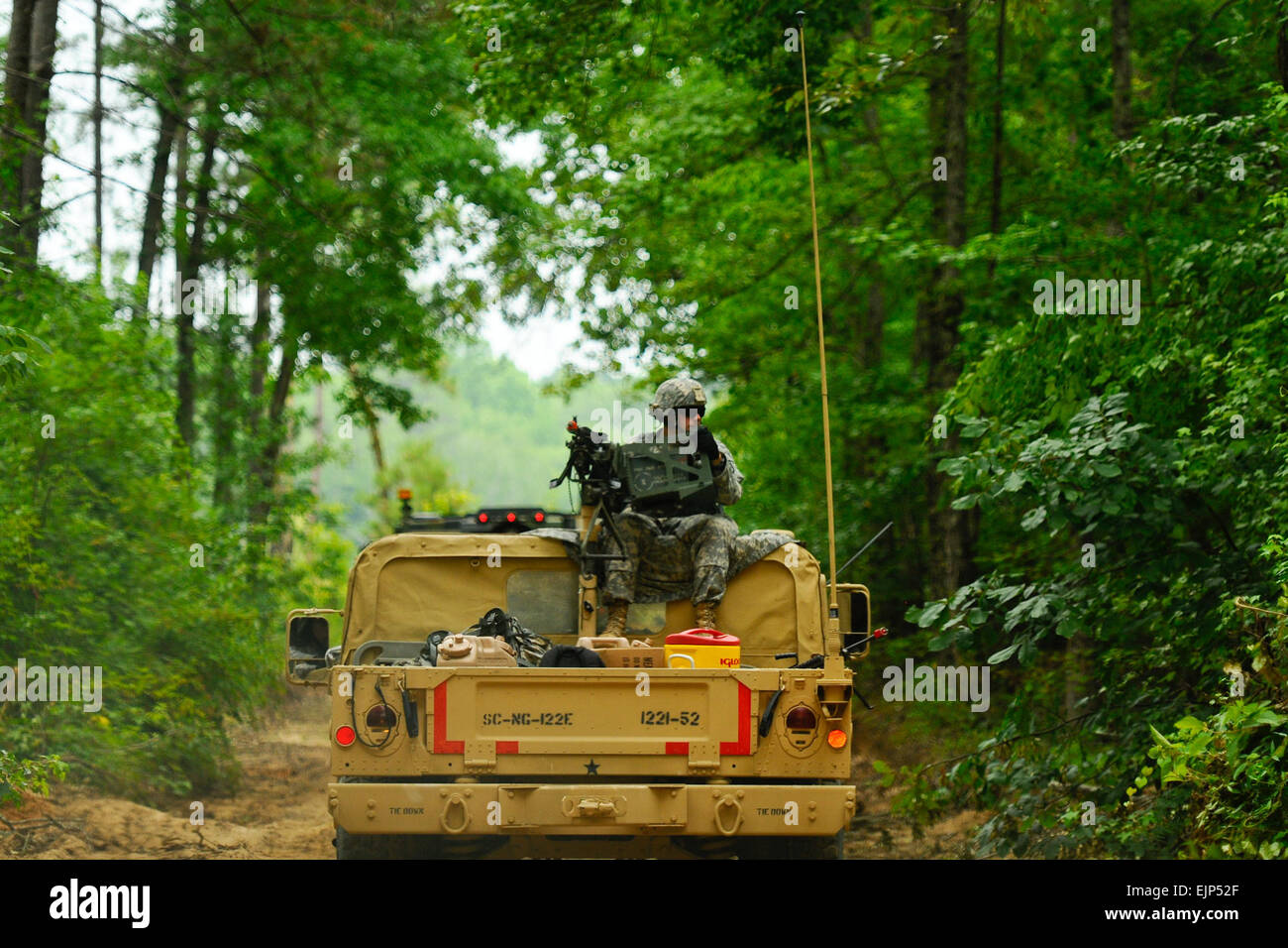 A U.S. Soldier, assigned to 1221st Route Clearance Company, South Carolina Army National Guard, gunner on top a HMMVV scans for threats during route clearance operations at McCrady Training Center, Eastover, S.C., June 24, 2014.  The Soldier’s mission is to locate improvised explosive devices during mounted convoy operations and dismounted walking patrols and dispose of IED’s once located.  U.S. Air National Guard photo by Tech. Sgt. Jorge Intriago Stock Photo