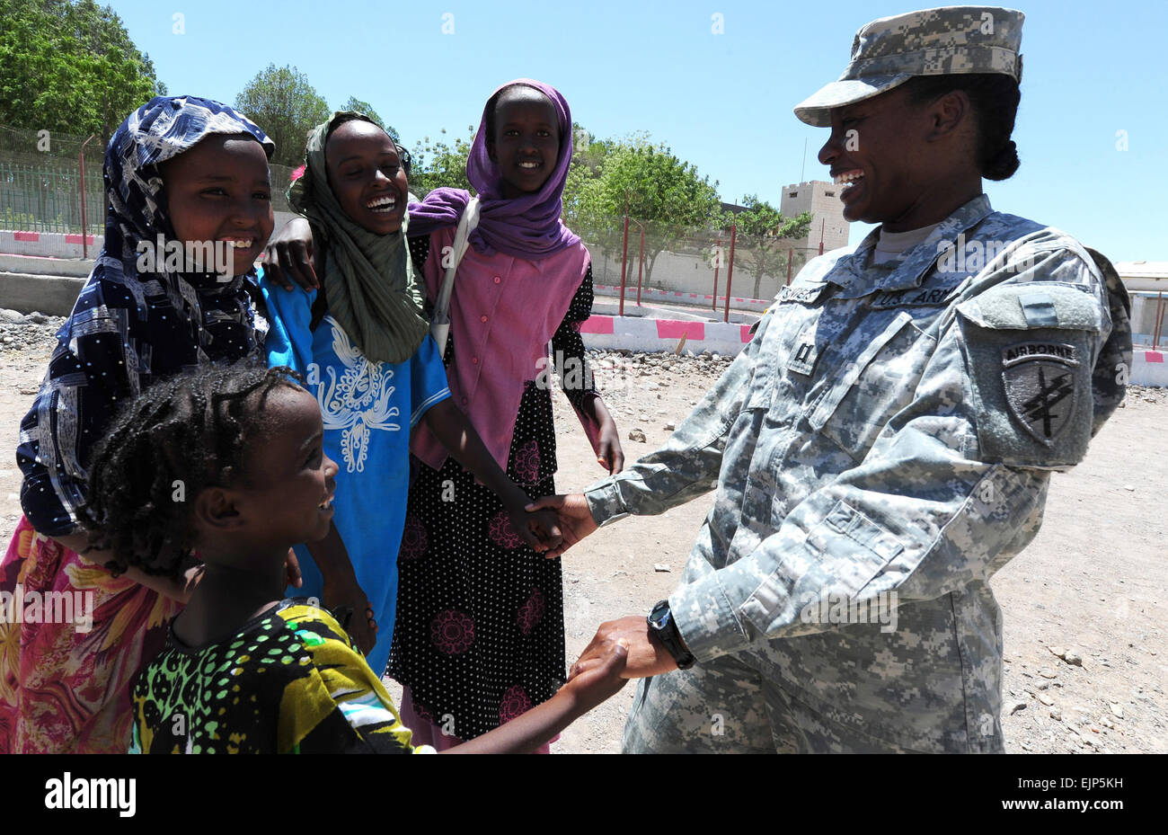 U.S. Army Capt. Courtney Sanders right, with the 402nd Civil Affairs Battalion, laughs with a group of girls in front of the Dikhil High School in Dikhil, Djibouti, on April 19, 2011.  The Battalion was working on renovating the school.  The project, which began April 16, is scheduled to refurbish six classrooms, the school's roof and an office.   Master Sgt. Dawn Price, U.S. Air Force. Stock Photo