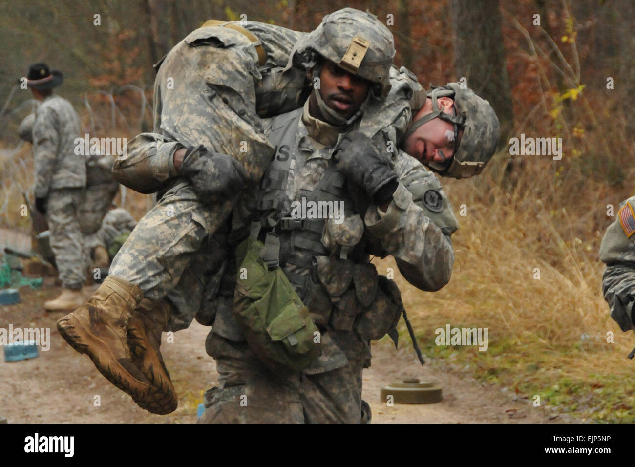 U.S. Army Sgt. Andre Lobban, a spur candidate with Palehorse Troop, 4th Squadron, 2nd Cavalry Regiment carries a casualty through a simulated minefield during a spur ride, Operation Swift Saber, Nov. 28, 2012, at Rose Barracks, Germany. U.S. Army  Spc. Joshua Edwards Stock Photo