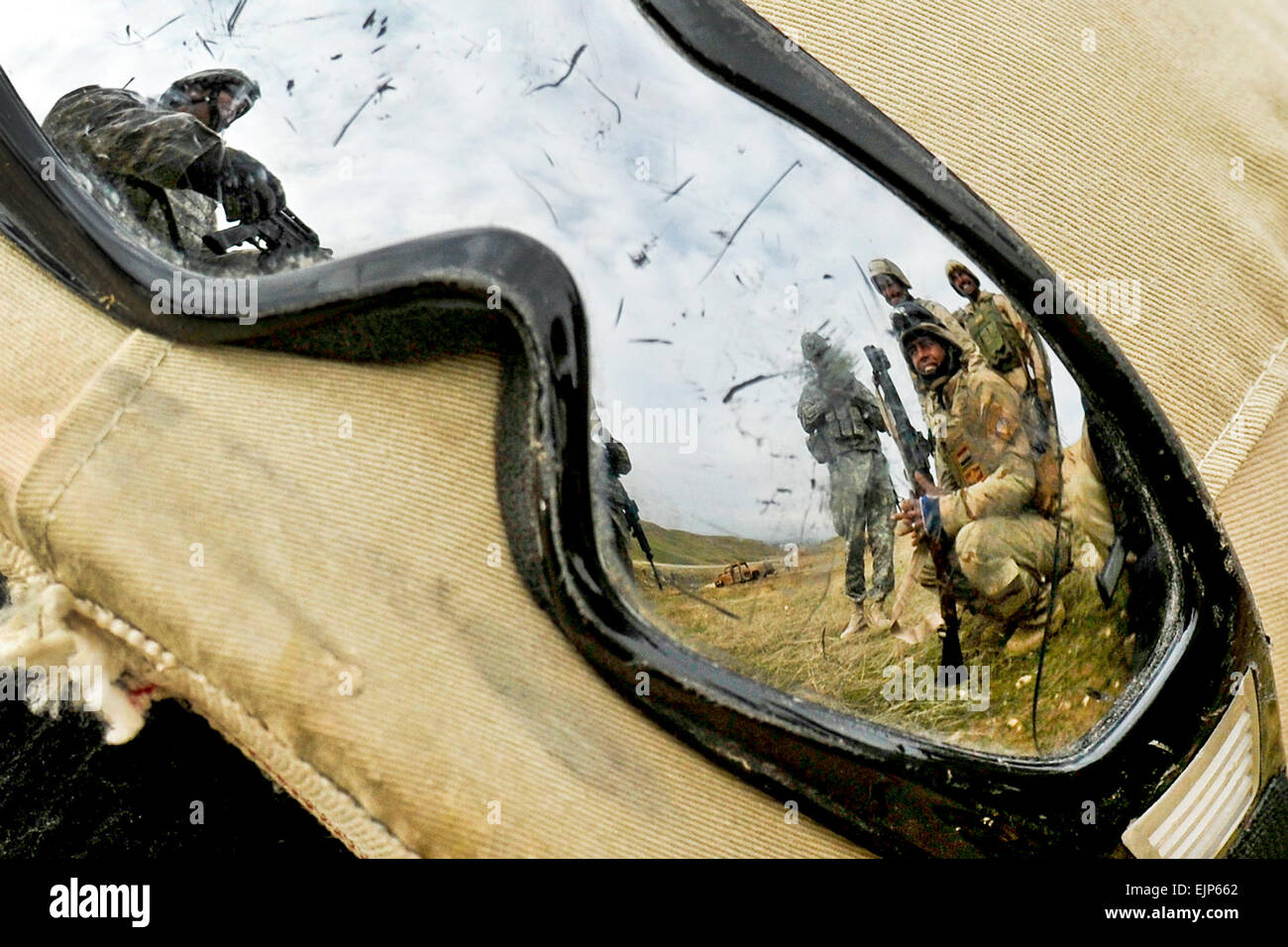 An Iraqi soldier's goggles catch the reflection of U.S. Army Staff Sgt. Kevin Murphy, left, as he instructs Iraqi soldiers of 2nd Battalion, 11th Brigade, 3rd Iraqi Army Division, on individual movement techniques at the Ghuzlani Warrior Training Center, Feb 2. Murphy and fellow Soldiers of 1st Squadron, 9th Cavalry Regiment, 4th Advise and Assist Brigade, 1st Cavalry Division, run Iraqi battalions through 25-day training cycles at the GWTC in order to teach them collective unit-level warfighting drills in order to bolster IA independence on national defense operations.  Sgt. Shawn Miller Stock Photo