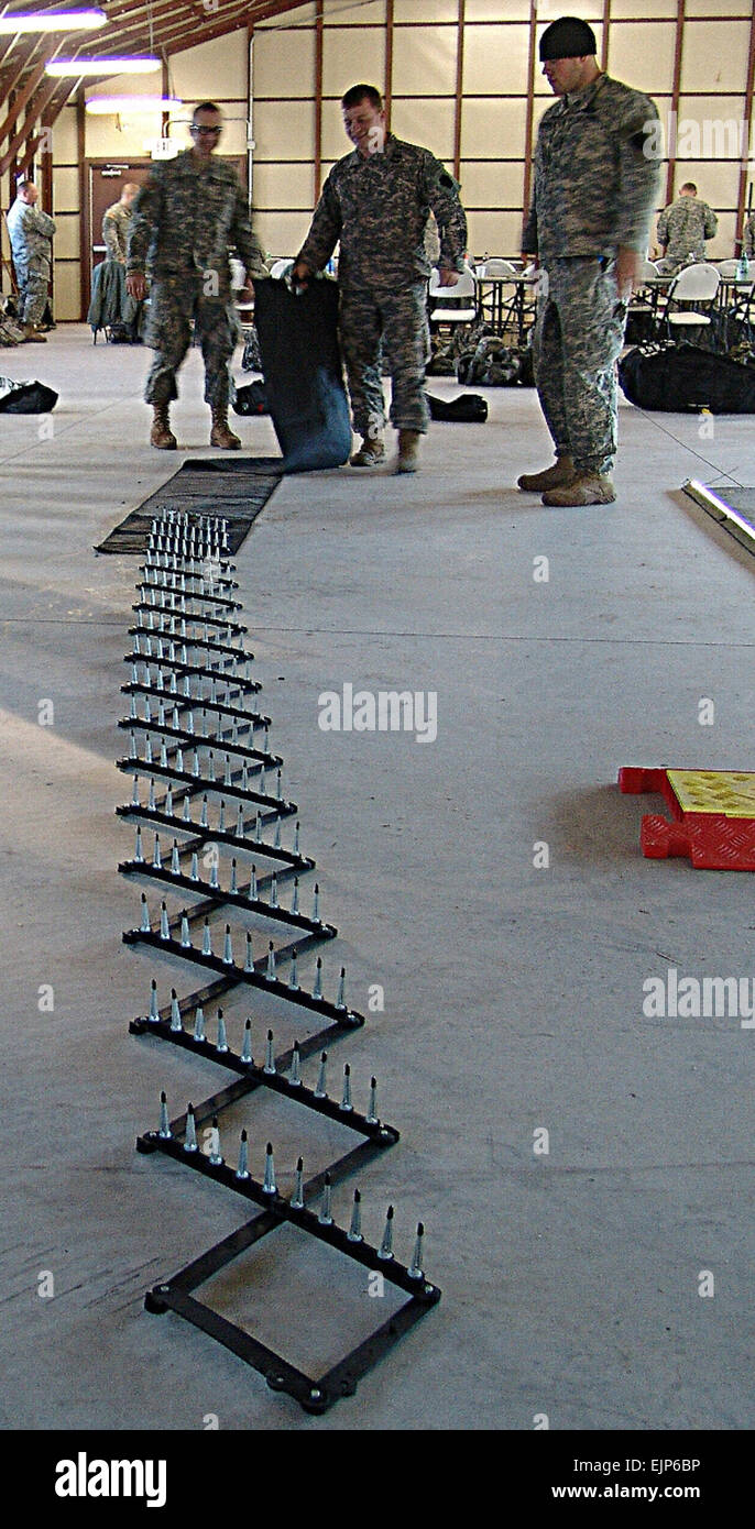 Members of the 56th Stryker Brigade Combat Team, 28th Infantry Division, practice laying out spike strips during non-lethal capability set training at Fort Dix, N.J. Stock Photo