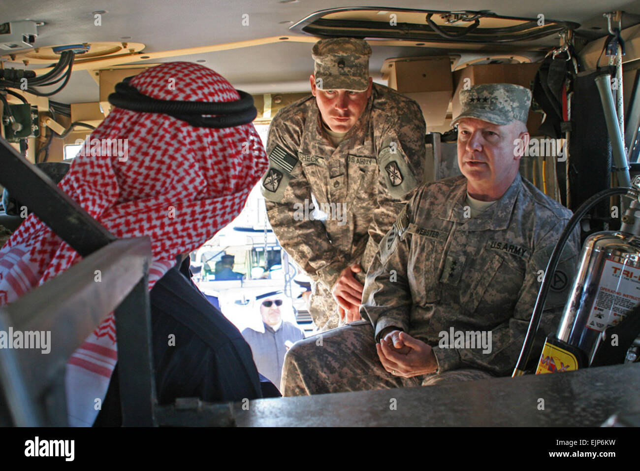 U.S. Army Lt. Gen. William G. Webster, right, and Soldiers teach Kuwaiti officials about U.S. military vehicles that will be using a new road designated by the Kuwaiti government for use by U.S. military convoys. The brief lesson occurred shortly after a ribbon cutting ceremony, Dec. 30, 2009, to celebrate the completion of the road.  Spc. Jason Adolphson Stock Photo
