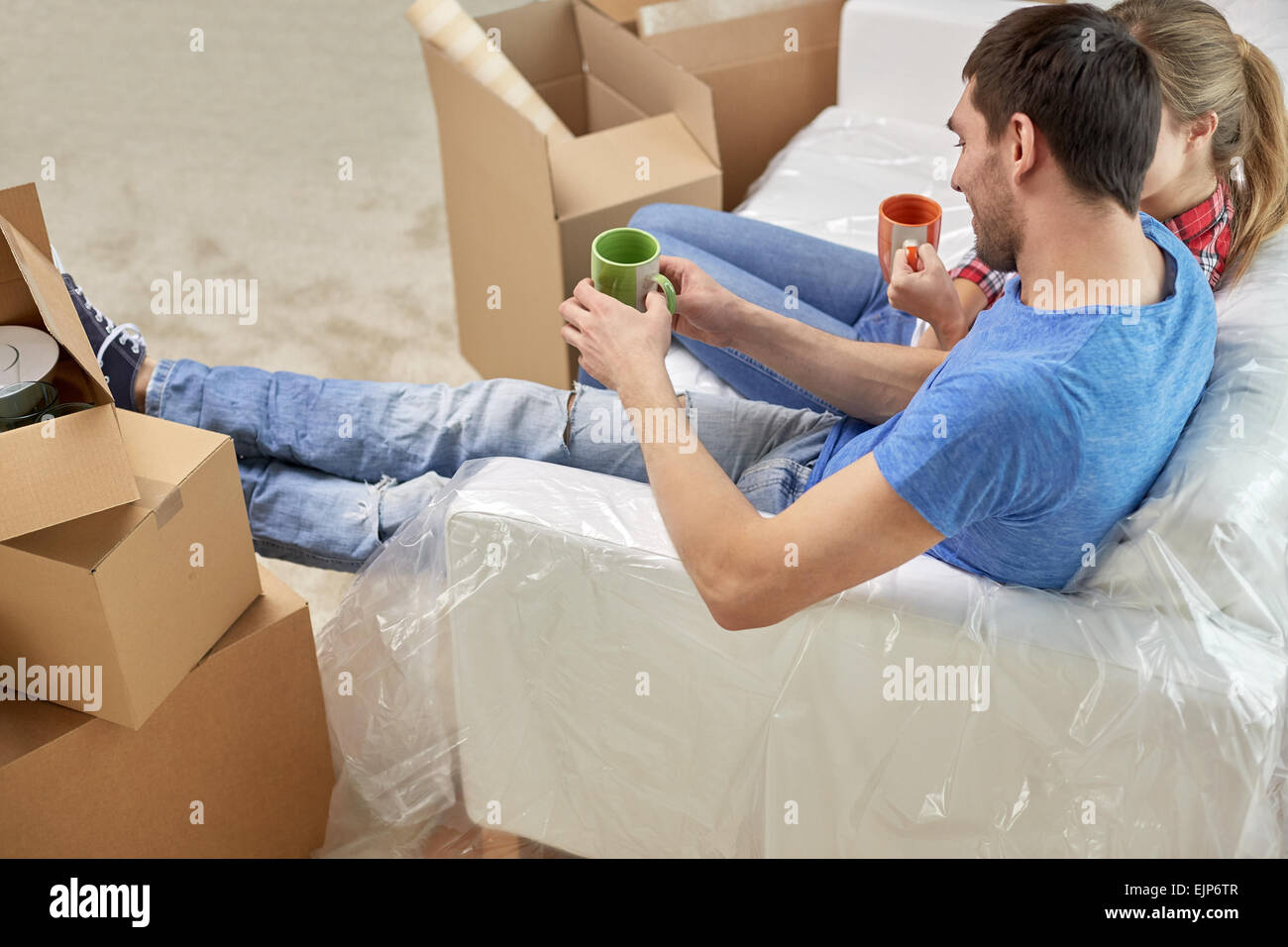 happy couple relaxing on sofa in new home Stock Photo - Alamy