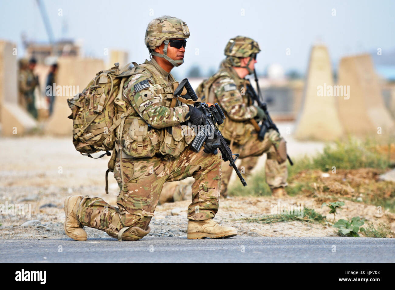 U.S. Army Spc. John Yifith, attached to 3rd Platoon, Alpha Battery, 2nd Battalion Airborne, 377th Parachute Field Artillery Regiment, takes a knee while conducting a security patrol outside of Forward Operating Base Salerno July 7, 2012. The purpose of the patrol was to facilitate members of the female engagement team as they conducted key leader engagements at both a girlsâ€™ school in the village of Mangas and discuss the midwife program in the village of Kunday. U.S. Army Staff Sgt. Jason Epperson Stock Photo