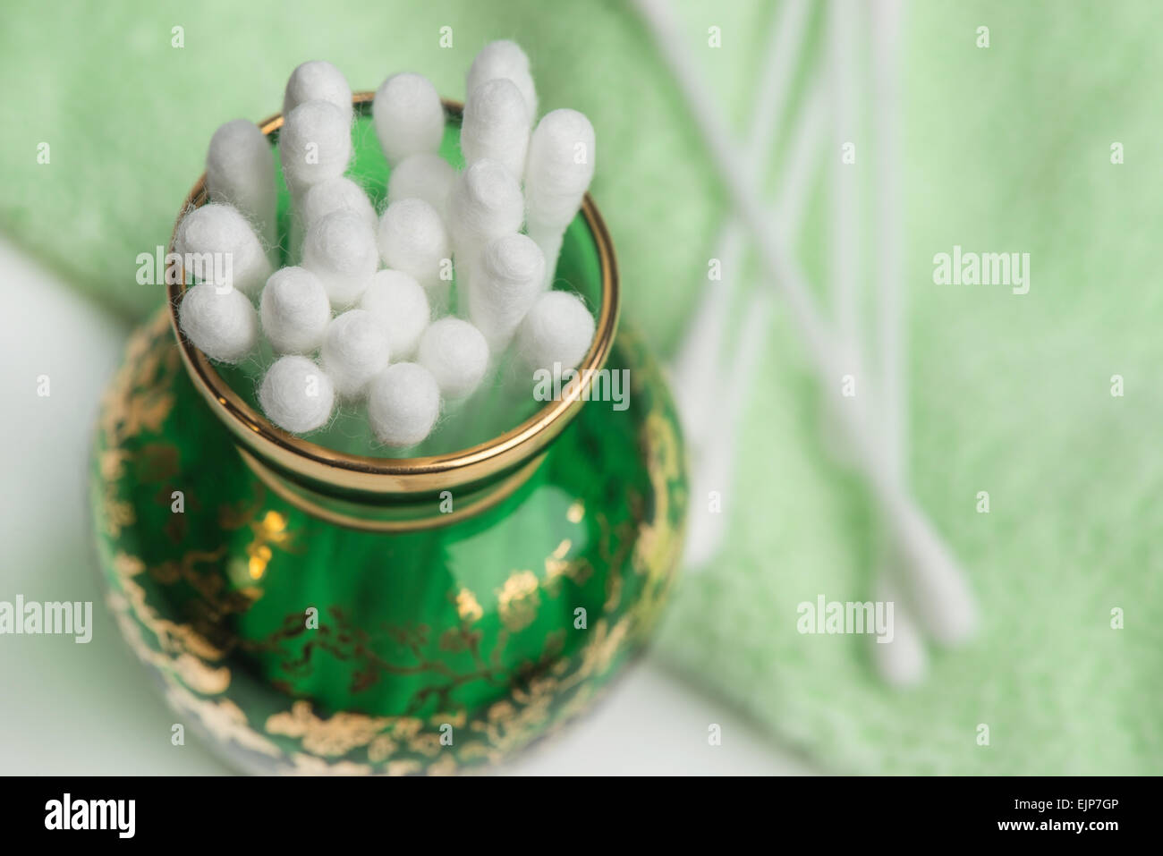 Cotton ear stick or coli in a green glass vase Stock Photo