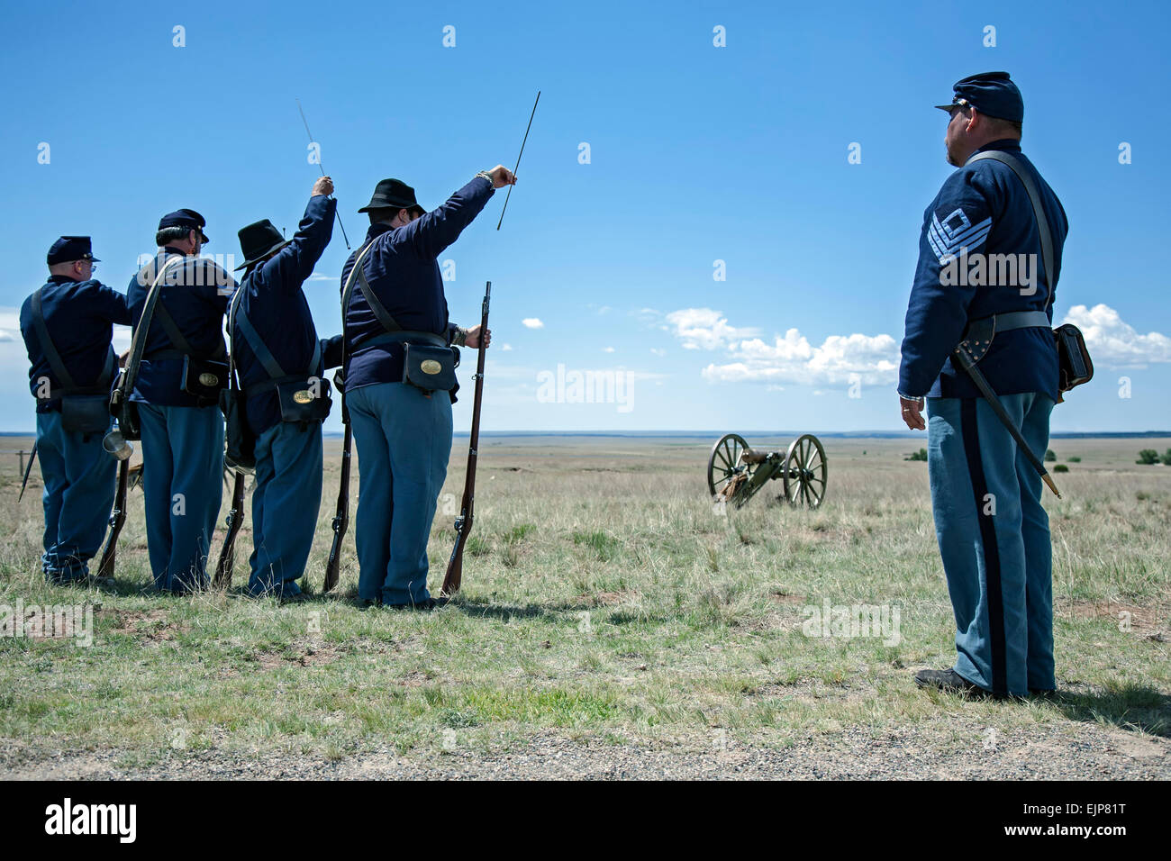 Civil War Era Union soldier reenactors, 1st NM Volunteers, 3rd Regiment, performing shooting drill, and cannon, Fort Union, NM Stock Photo