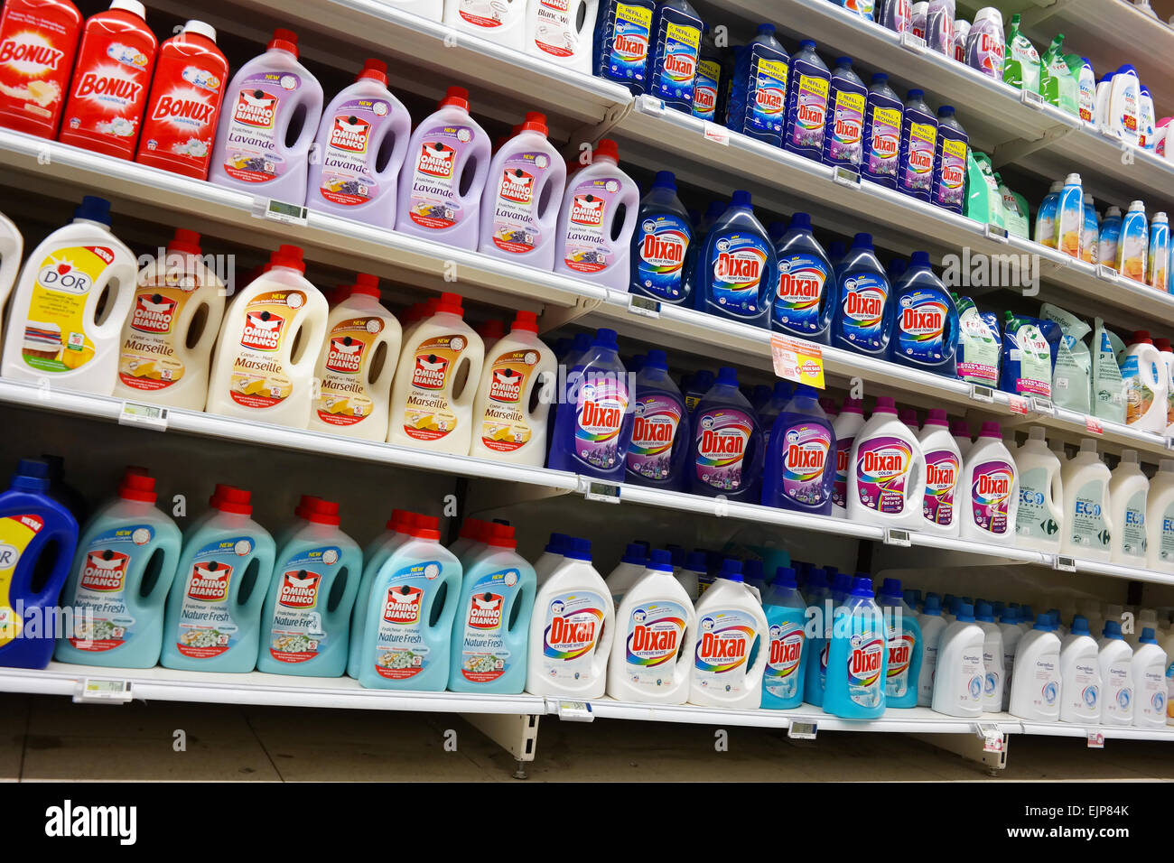 Shelves filled with Bottles liquid laundry detergent in a Carrefour Hypermarket in Belgium Stock Photo