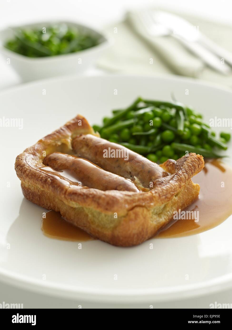 plated meal of toad in the hole Yorkshire pudding and Sausages with