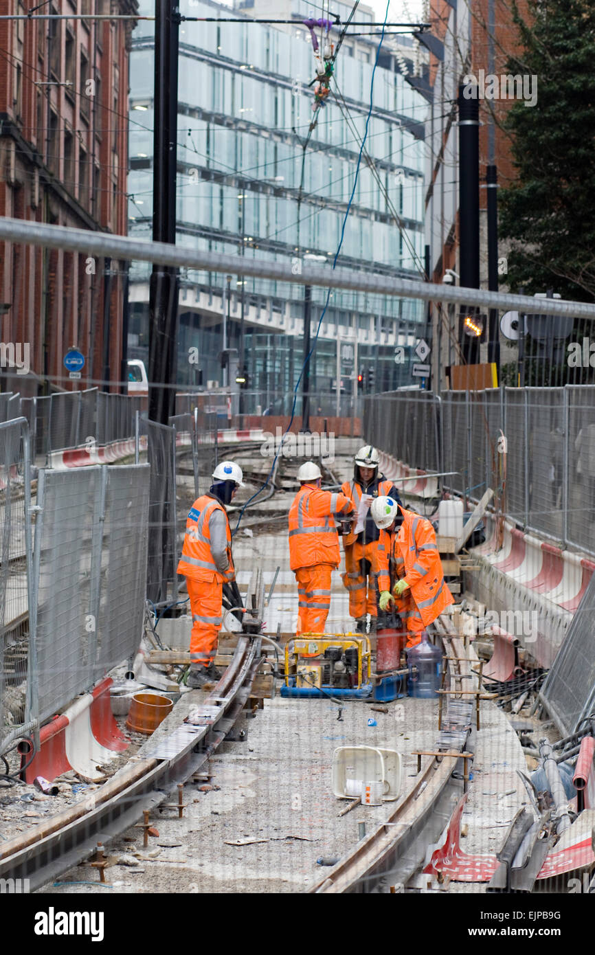 Workmen working on the Tram lines in Manchester's city center Stock Photo
