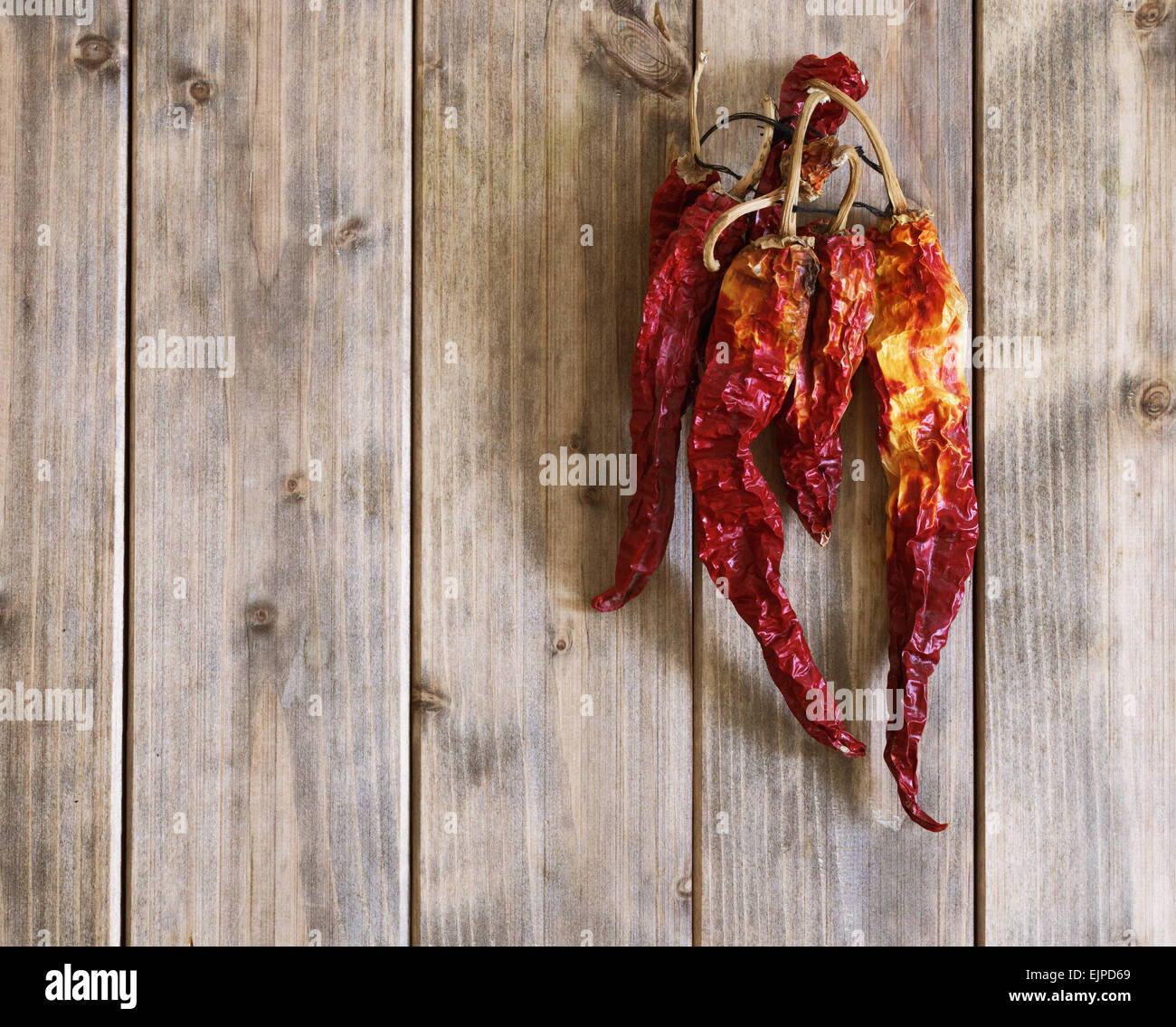 dry red hot chili peppers on a wooden table top view Stock Photo - Alamy
