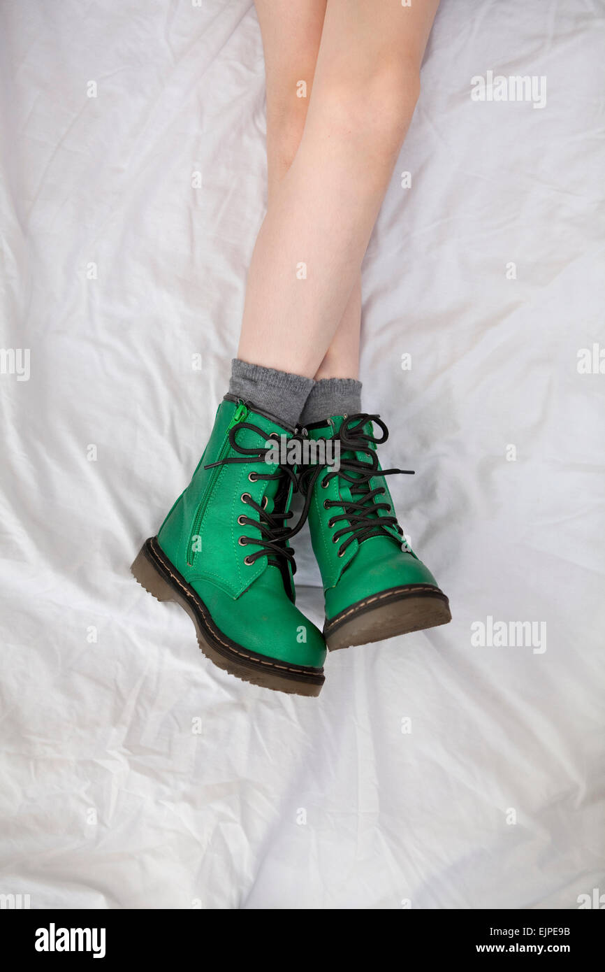 Girl in green Doc Marten style boots, lying on a white, wrinkled bedsheet  Stock Photo - Alamy