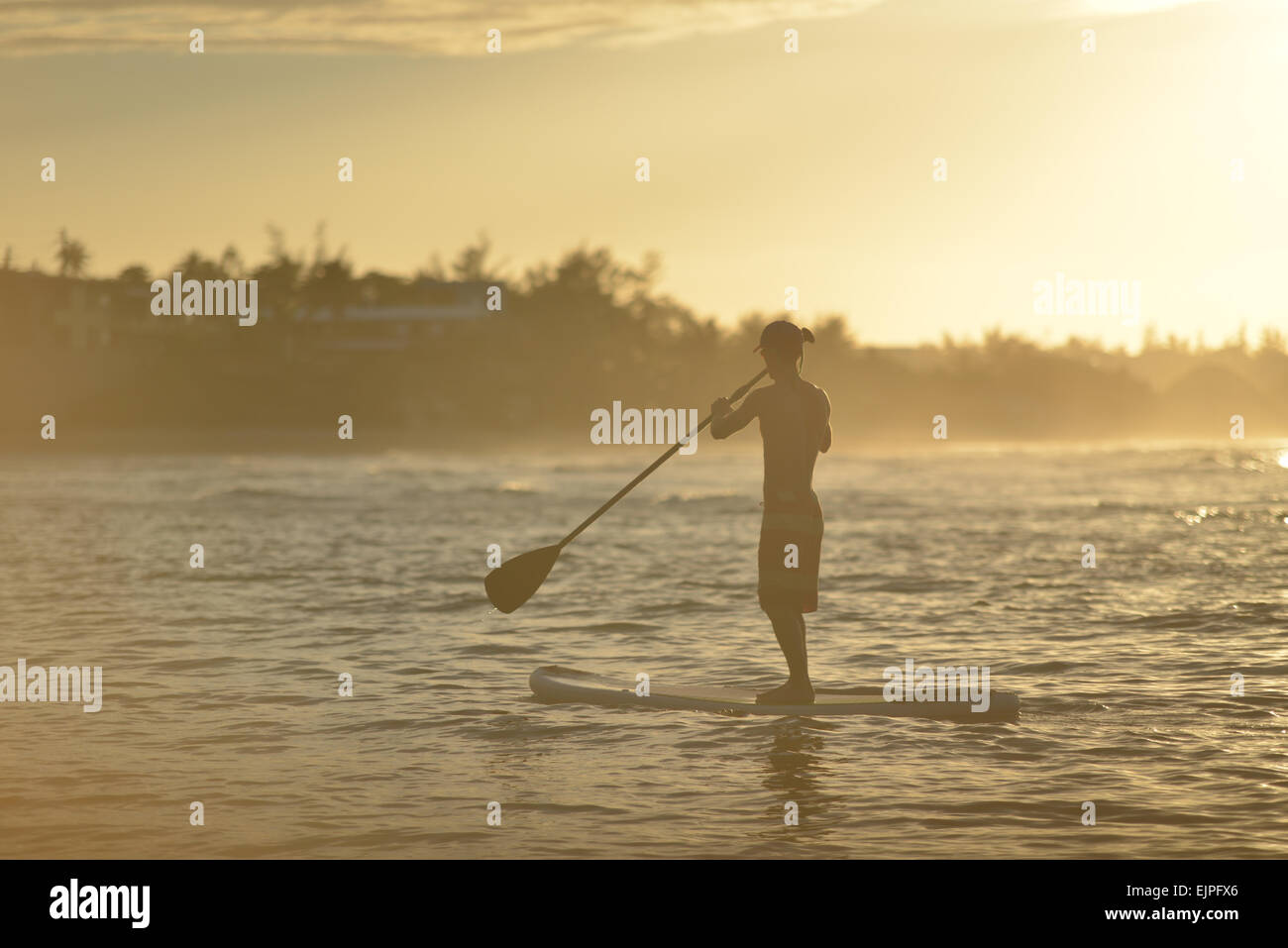 Silhouette of a man on a paddle board during a stunning sunset at Jobos beach. Isabela, Puerto Rico. Caribbean Island. Stock Photo