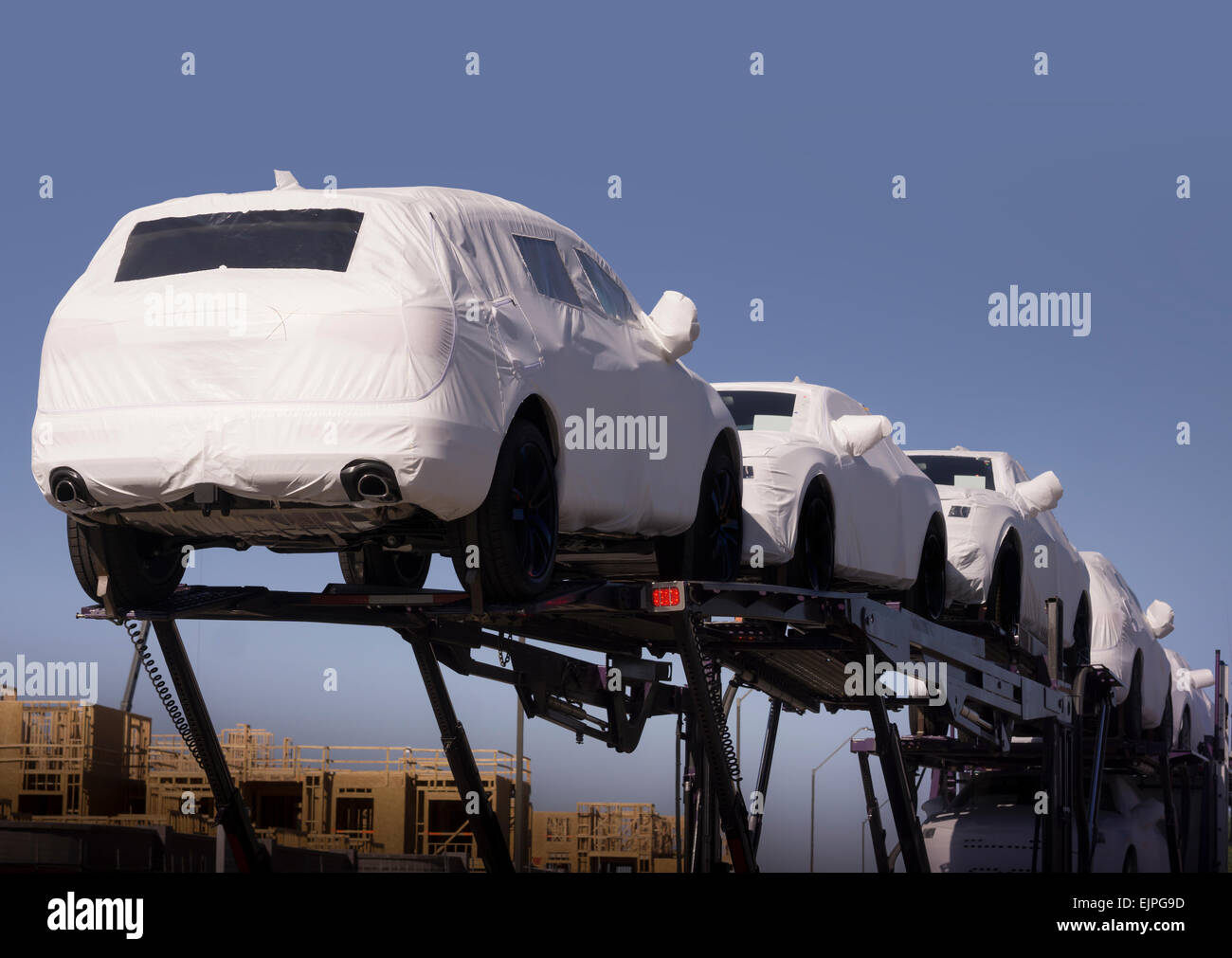 New cars under wraps being transported to dealership Stock Photo