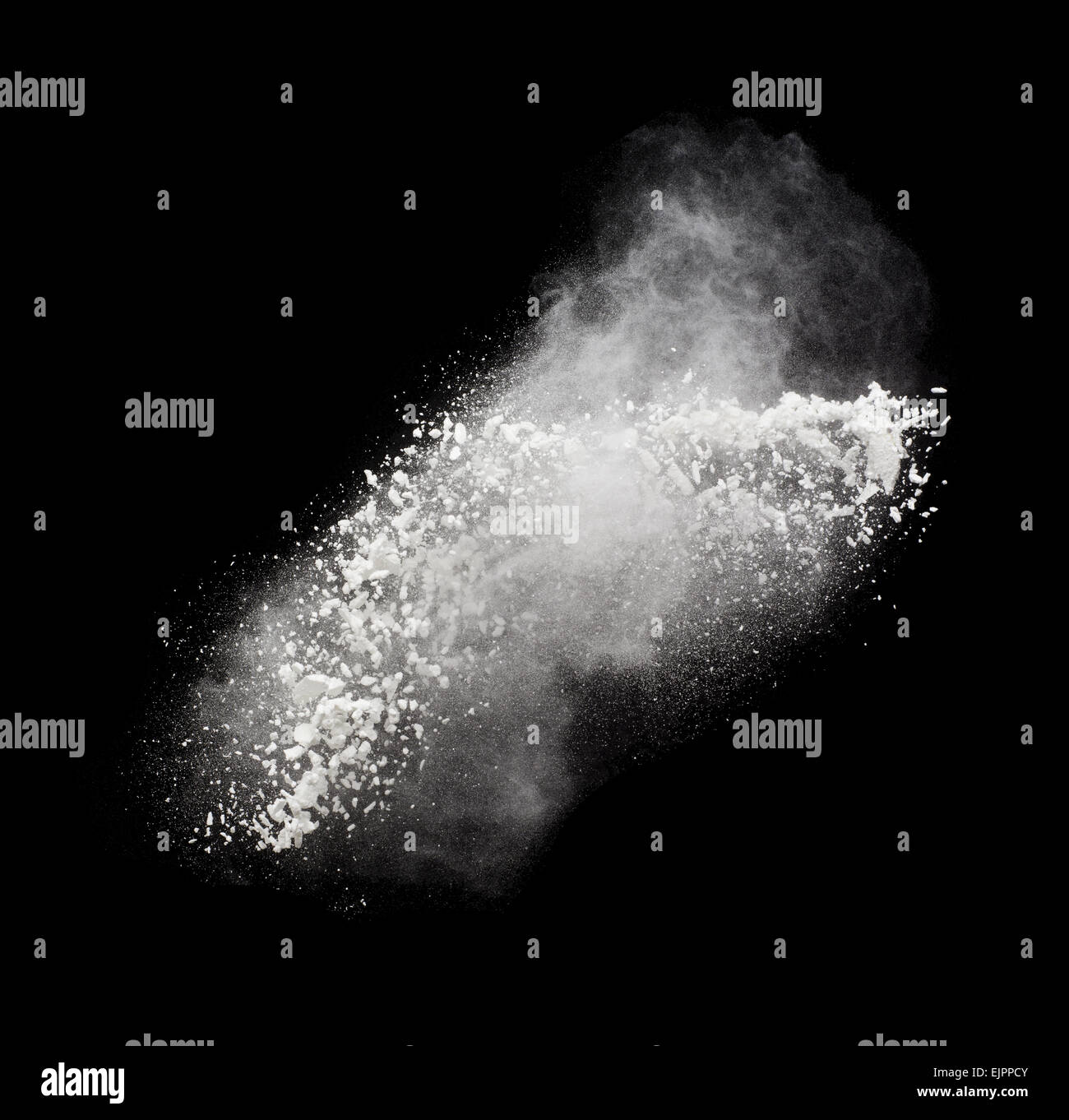 Freeze motion of white powder exploding, isolated on black. Abstract ...