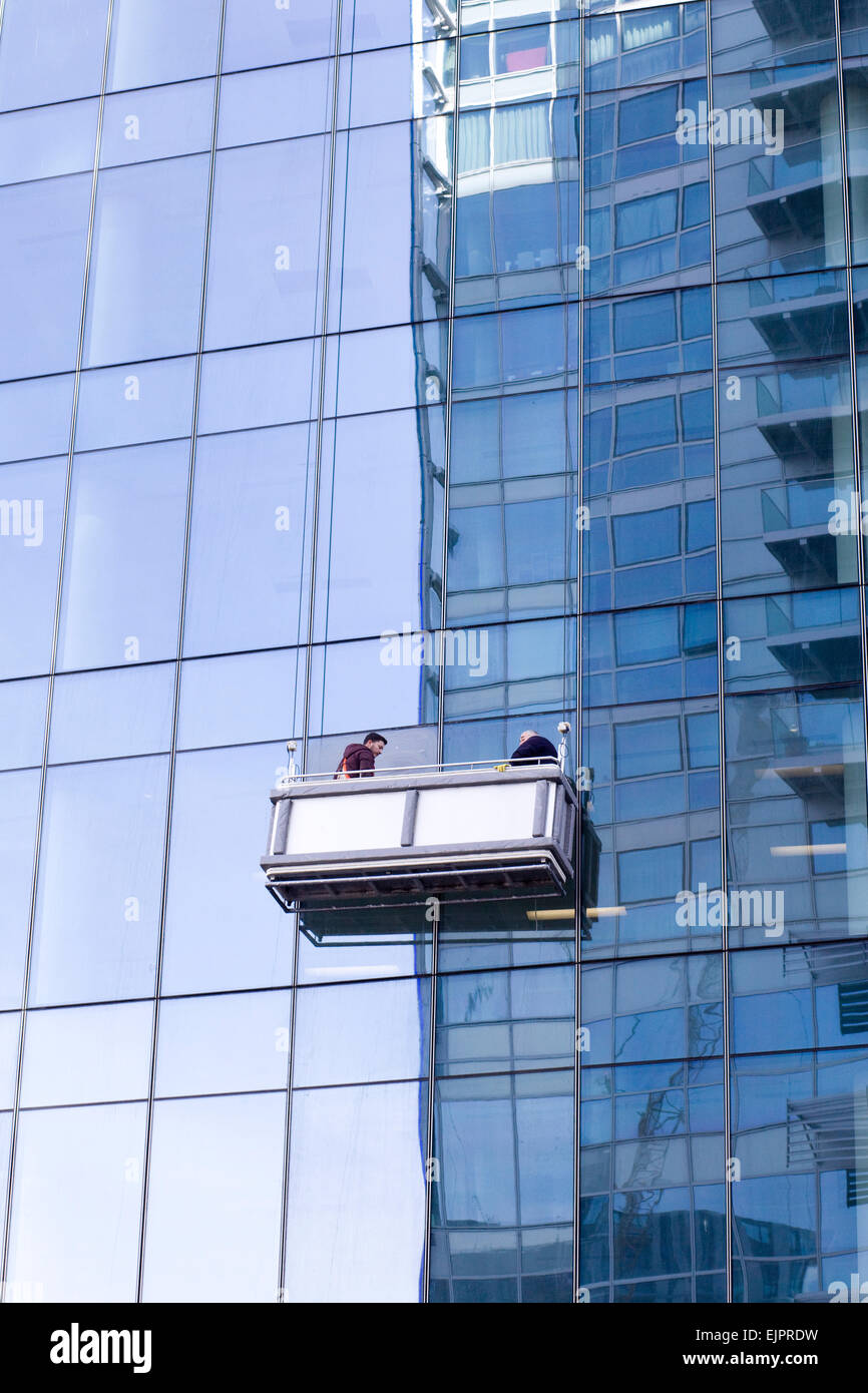 Men cleaning windows in a Aerial Work Platform Stock Photo