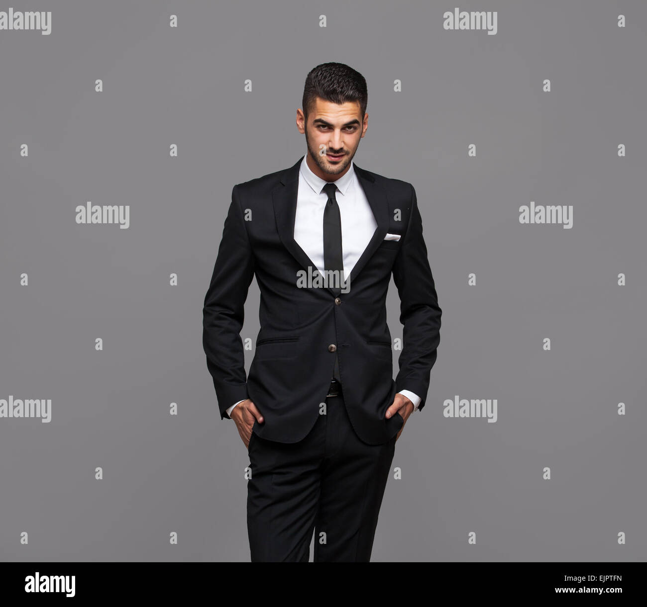 handsome hispanic elegant man in black suit on grey background Stock Photo  - Alamy