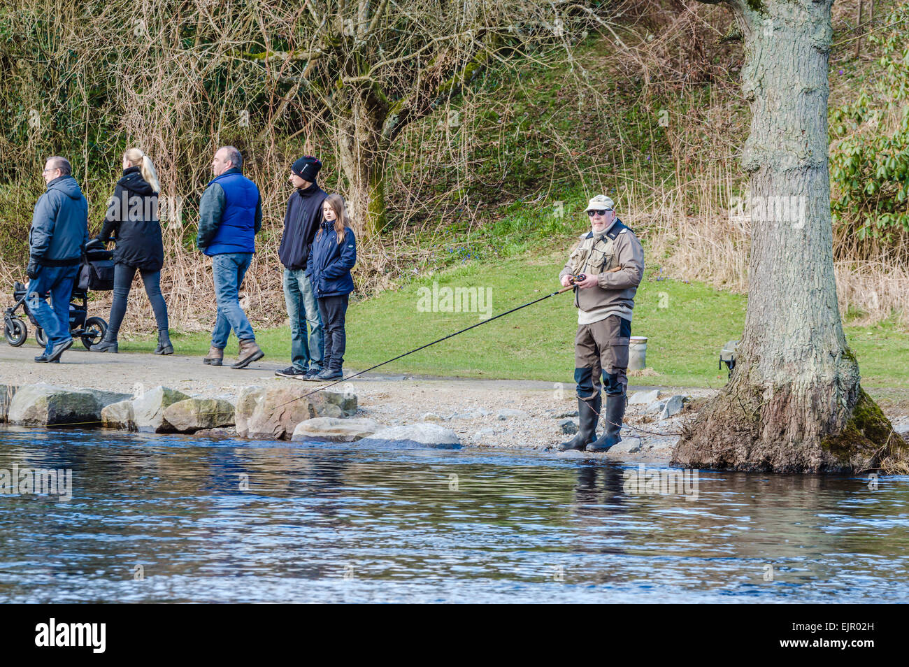 Morrum, Sweden - March 28, 2015: Premiere day for trout and salmon fishing. Spectators walk by and look while people fish. Stock Photo