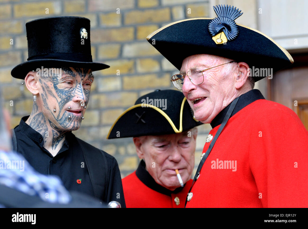 Chelsea Pensioner speaking to a heavily tattooed and pierced man Stock Photo