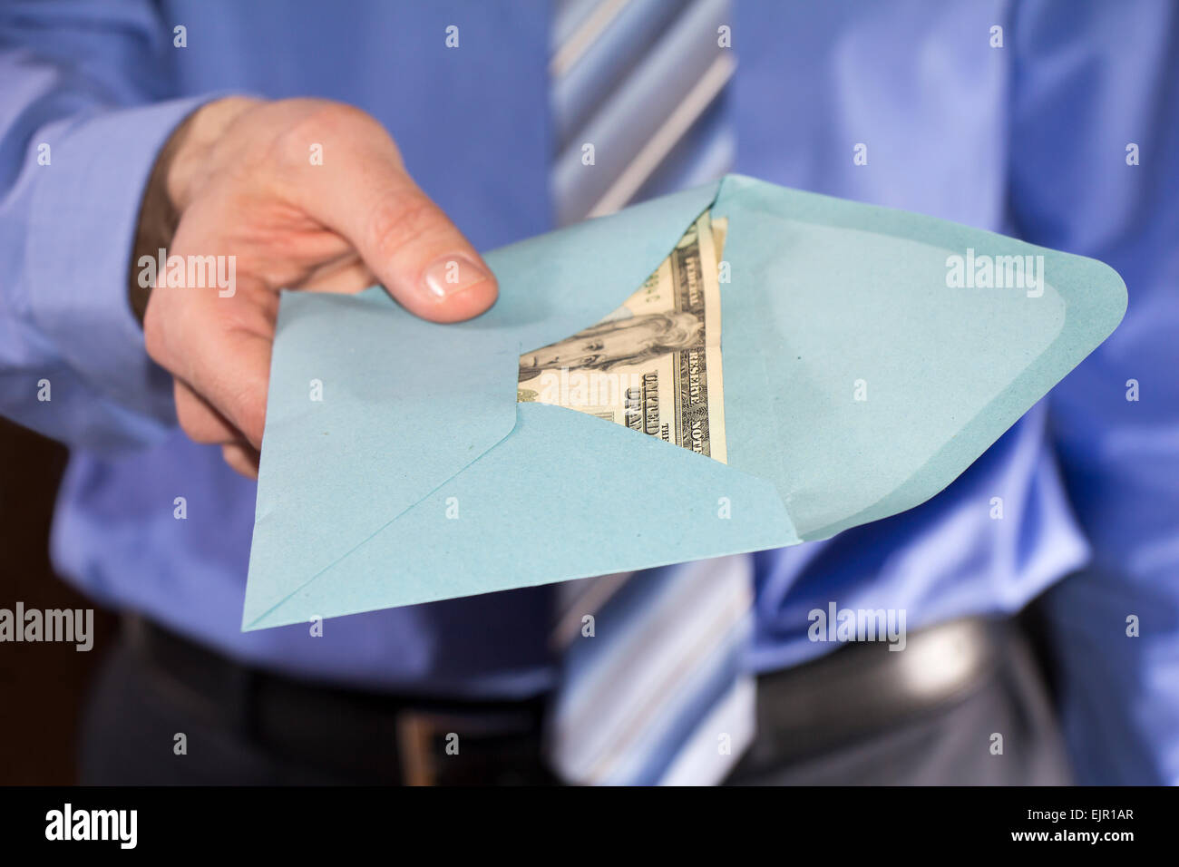 Man in a blue shirt, giving bribe in a blue envelope Stock Photo