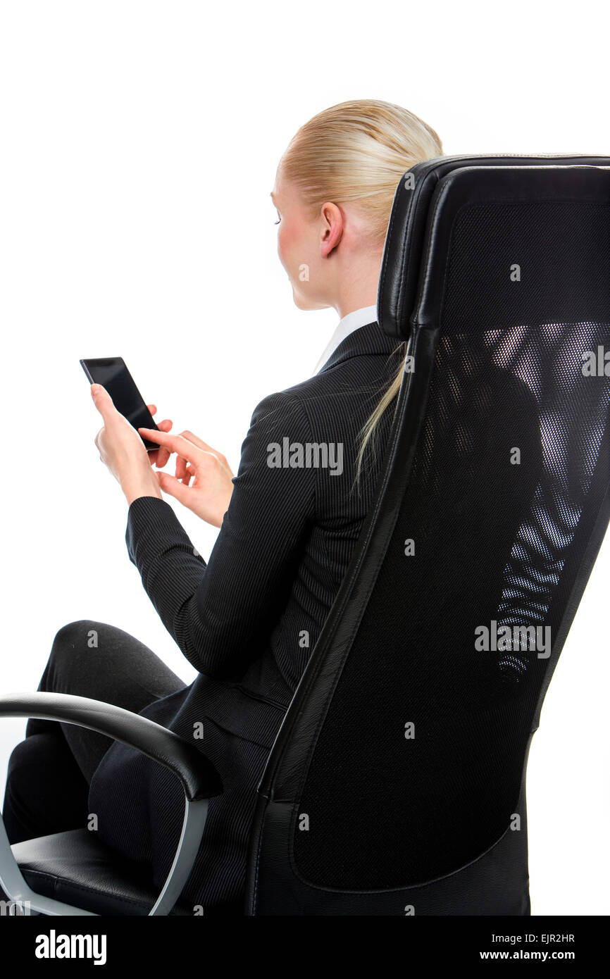 blonde smiling businesswoman seated on a chair with mobile phone Stock Photo