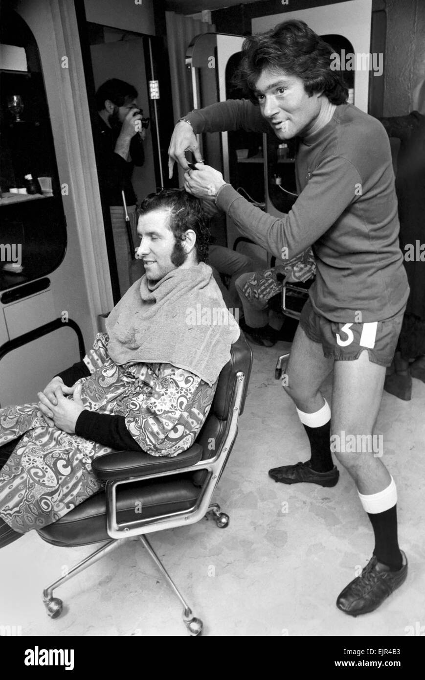 Football fan Vidal Sassoon made a solemn promise that if Chelsea reached the final of the Football League Cup the players and their wives would all get a free hair-do for the occasion. Chelsea are in the Final and Vidal kept this promise. Vidal Sassoon's dressed in Chelsea's Football strip and seen cutting the hair of England and Chelsea's Centre Forward Peter Osgood. March 1972 72-2010-001 Stock Photo