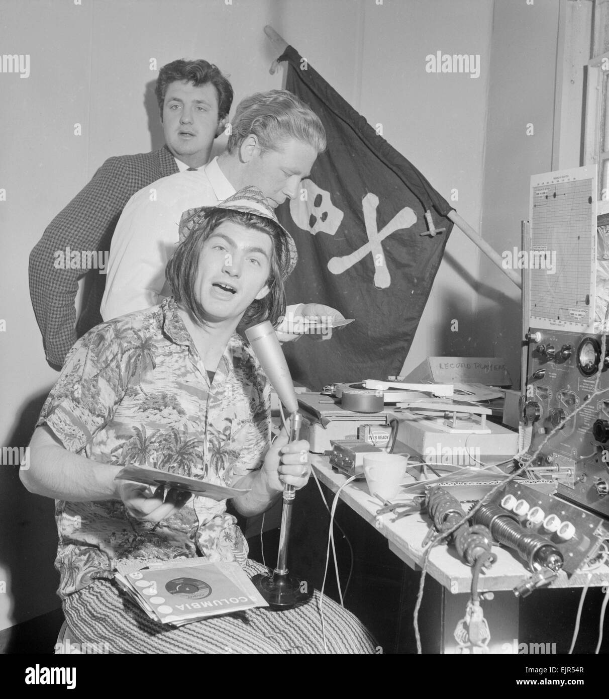 Pirate Radio Station Sutch Radio, which is broadcasting from Radio City, a complex of forts in the Thames Estuary, 28th May 1964. Pictured: Lord Sutch (seated), Reg Calvert (fair hair) & Brian Paul (at rear) Lord Sutch a.k.a. Screaming Lord Sutch. Reg Calvert Murder Case 1966. It was alleged that Mr Calvert was shot and killed at teh home of Mr Smedleyin Wendens Ambo near Saffron Walden (21st June 1966). Reg Calvert was head of rival pirate radio station Radio City & manager of The Fortunes pop group. Major Oliver Smedley was acquitted of murder on the grounds of self defence. Stock Photo