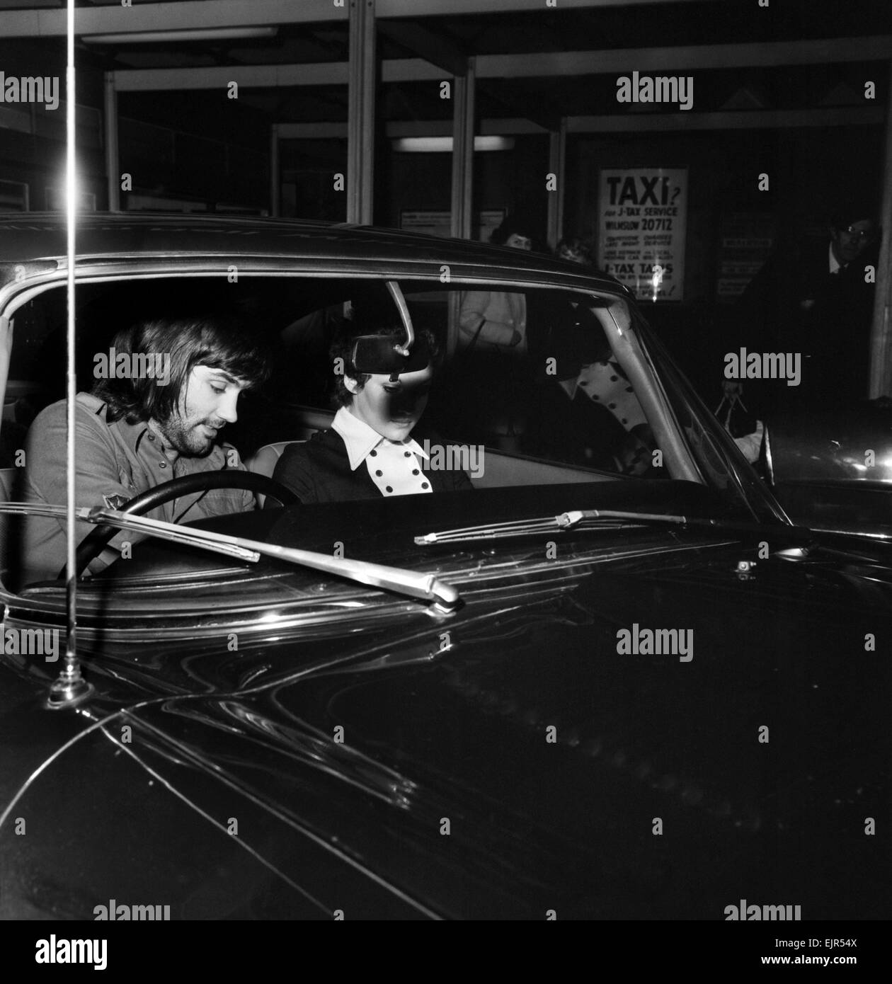 George Best and Carolyn Moore: George Best prepares to make his dash from Wilmslow railway station with his girl-friend Carolyn Moore. She had travelled from Crewe by train. January 1972 72-0329-002 Stock Photo