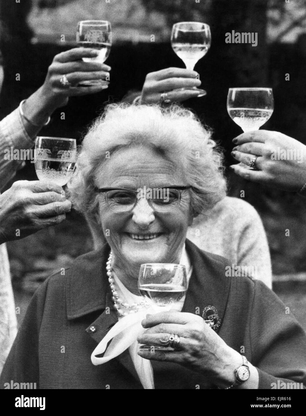 75 year old Mrs. Emily Ellen Smith, known as Nell to her friends celebrating at her Nice flat in Croydon, after hearing of her British Empire Medal award for her service to Plume making. She lives at Drury-lane, London and has worked at Appletons, Chiswick since she was 14. Pictured 11th June 1977. *** Local Caption *** Pensioners OAP Senior Citizens Stock Photo