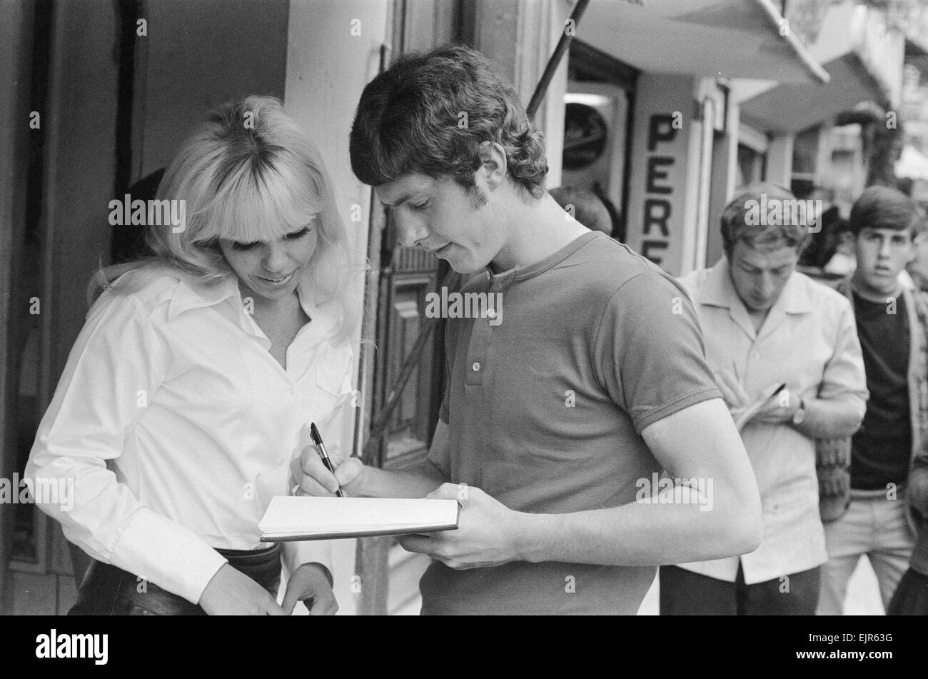 1970 World Cup Finals in Mexico. England footballer Brian Kidd signs an autograph for a woman as the team stroll around the Zona Rosa part of Mexico City during their shopping trip there. 11th May 1970. Stock Photo