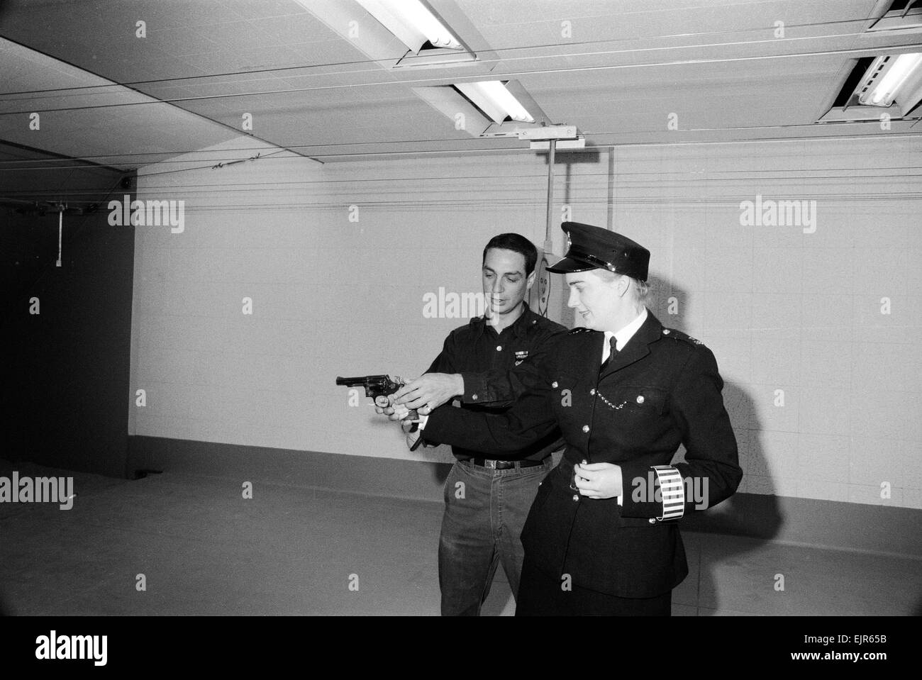 English police officers tour a firing range at a New York Police Department in America 2nd October 1964. Bobby is shown, by Instructor, how to hold a gun correctly *** Local Caption *** WatScan - - 05/01/2010 Stock Photo