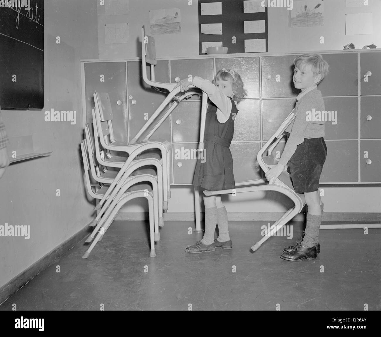 Two pupils seen here stacking chairs following assembly at the new primary school at Upper Tulse Hill. 5th December 1952 *** Local Caption *** watscan - - 12/01/2010 Stock Photo