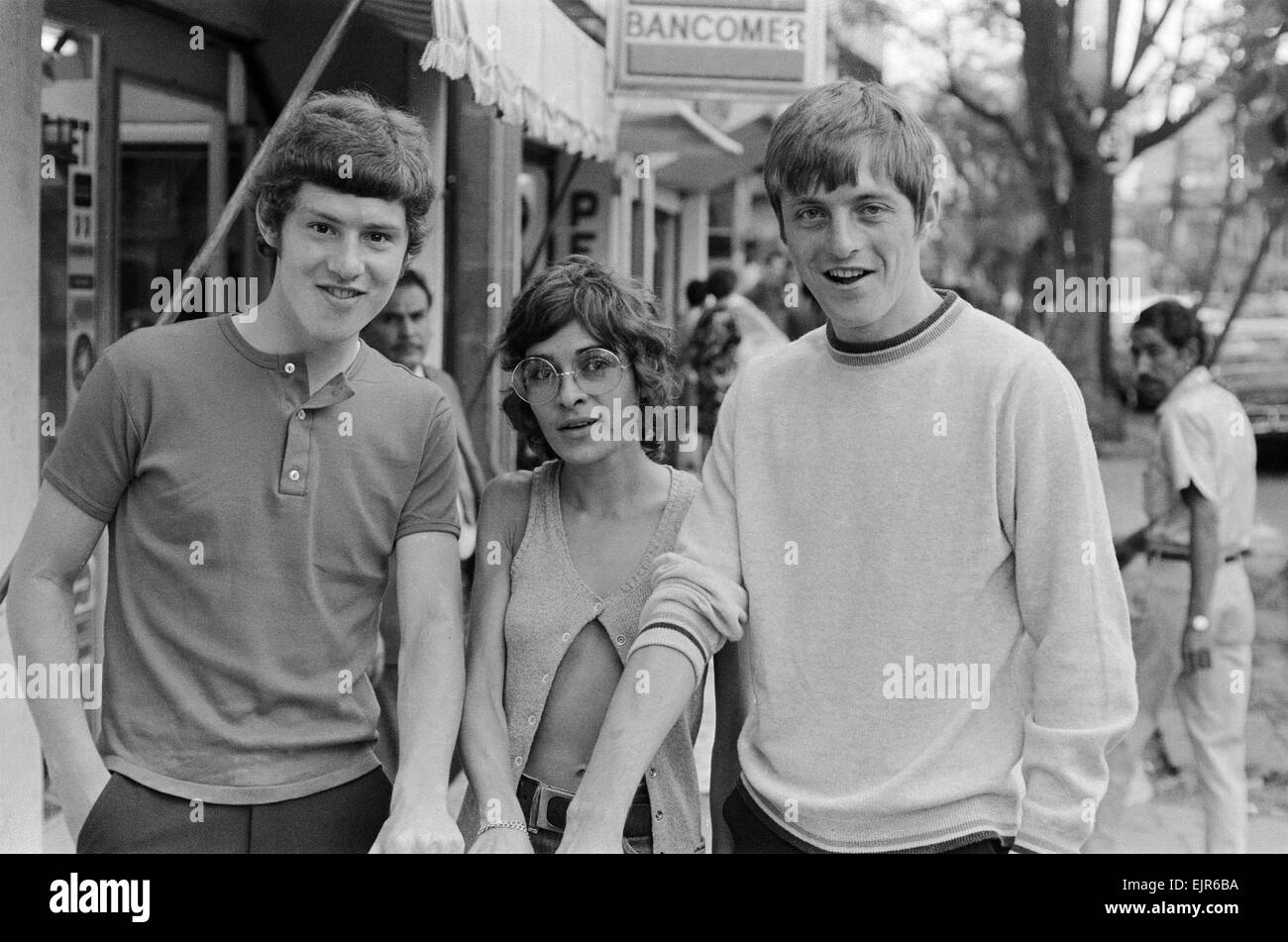 1970 World Cup Finals in Mexico. England footballer Brian Kidd (left) and Allan Clarke pose with a woman, showing off their tanned arms, as the team stroll around the Zona Rosa part of Mexico City during their shopping trip there. 11th May 1970. Stock Photo