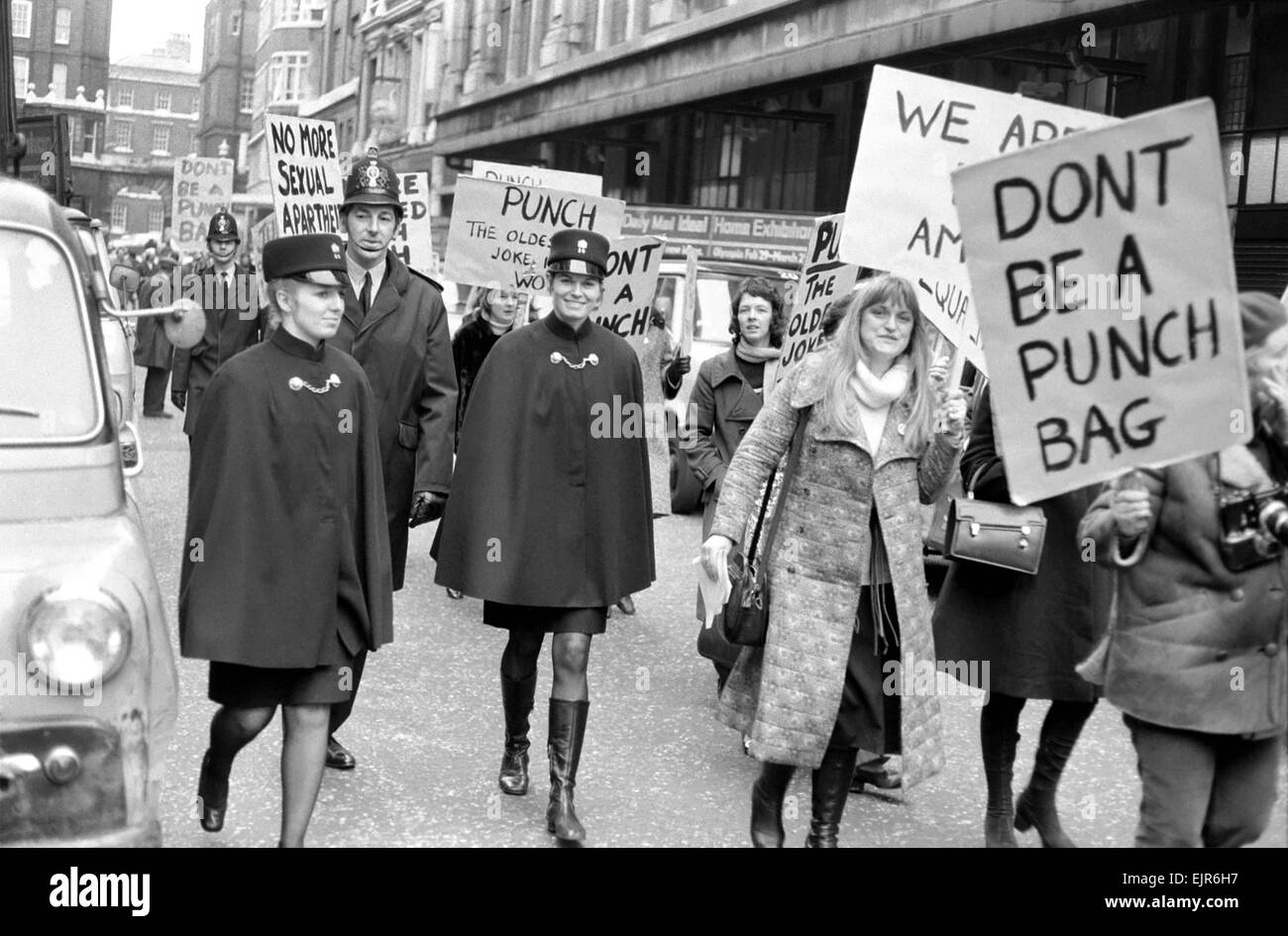 Outside the offices of Punch members of the women's liberation protested against their so-called segregation for male workers in the newspaper and advertising media later escorted by police two inspectors one sergeant two policewomen and seven men. They marched through Fleet Street to the Punch Tavern where they sold some women's Lib Buttons to some police officers. Marching through feet street. February 1972 72-1922-005 Stock Photo