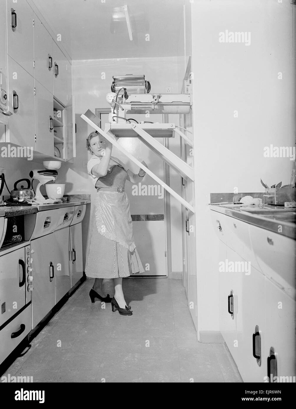Mrs Susan Davies seen here putting away here rotary iron in a kitchen full of labour saving gadets. 14th September 1952 Stock Photo