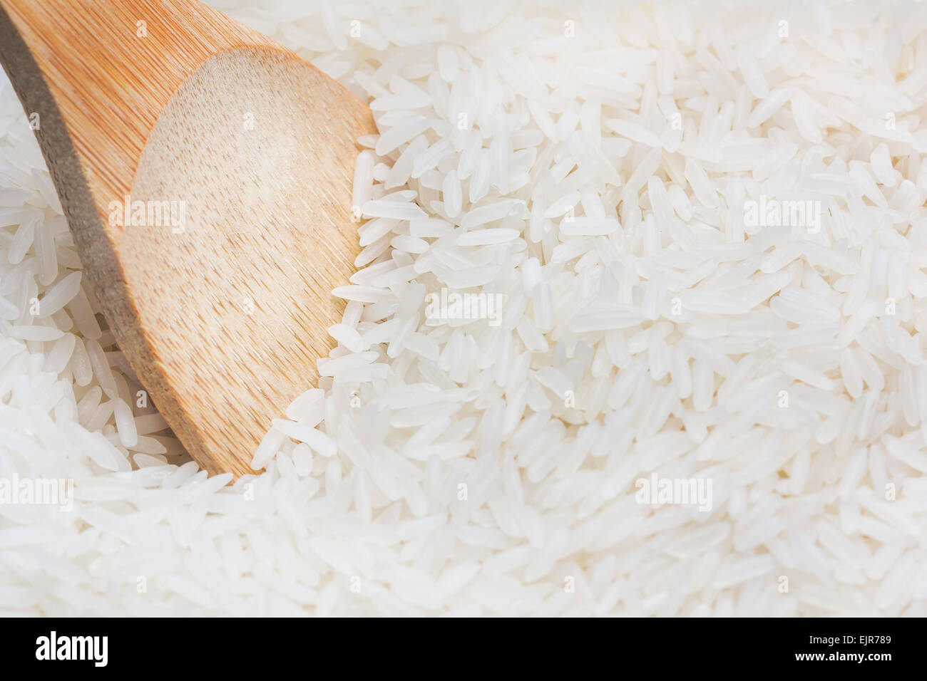 uncooked rice with wooden spoon close up Stock Photo